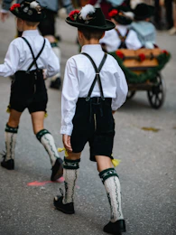 Two boys in traditional bavarian lederhosen walking in a parade