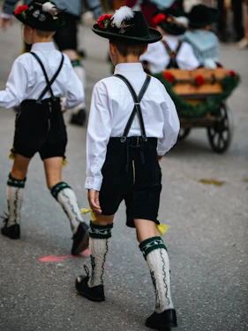 Two boys in traditional bavarian lederhosen walking in a parade