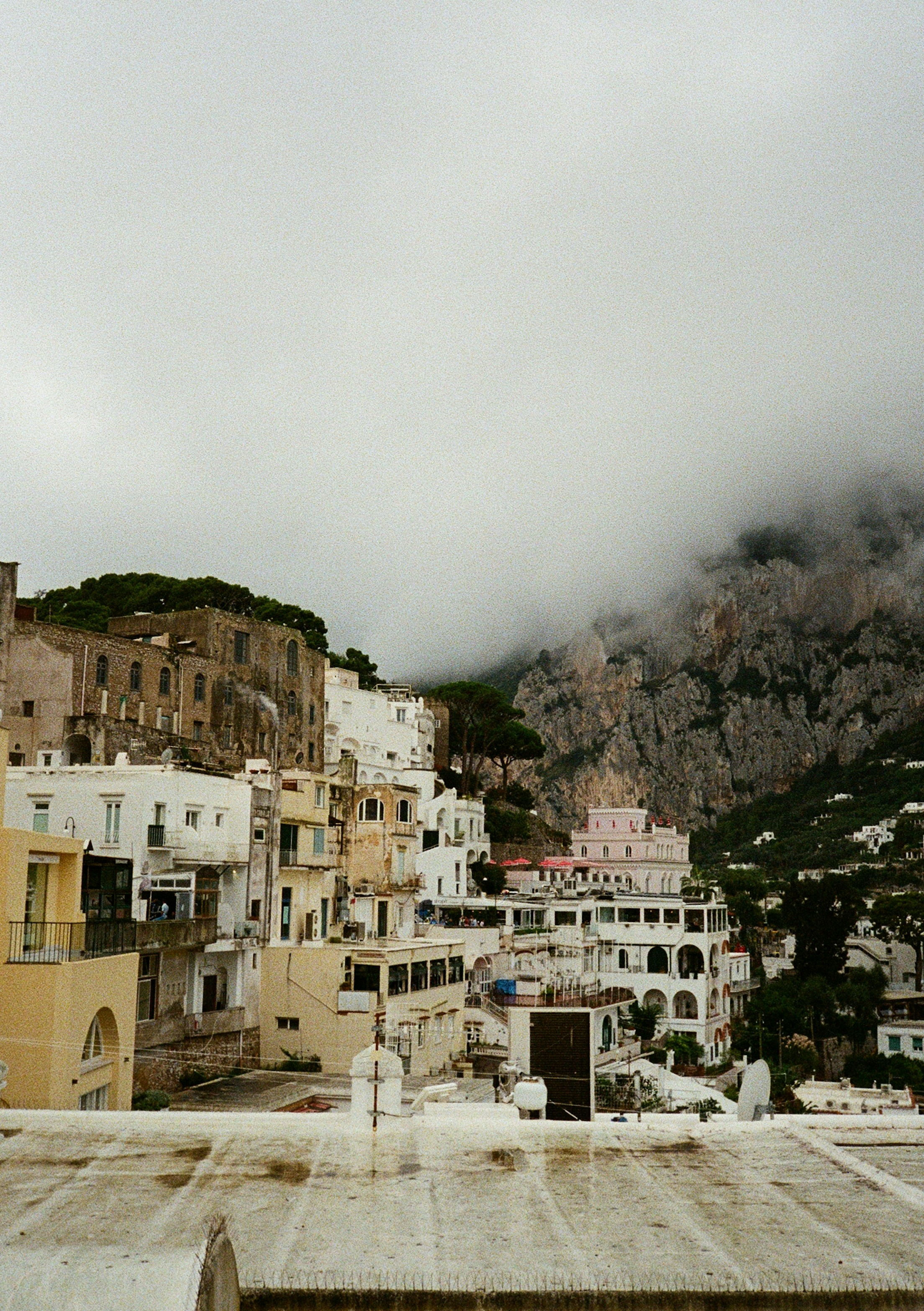 Coastal village nestled against misty mountainside