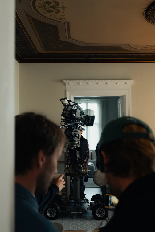 Filming crew with camera on dolly in room