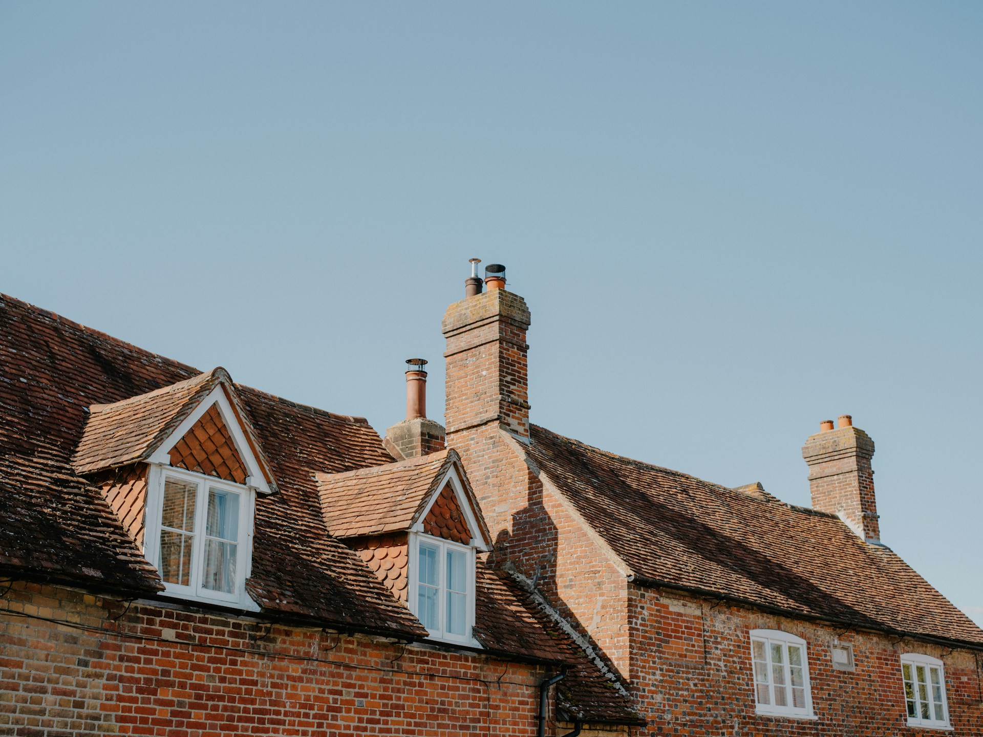 Brick houses with dormer windows under blue sky