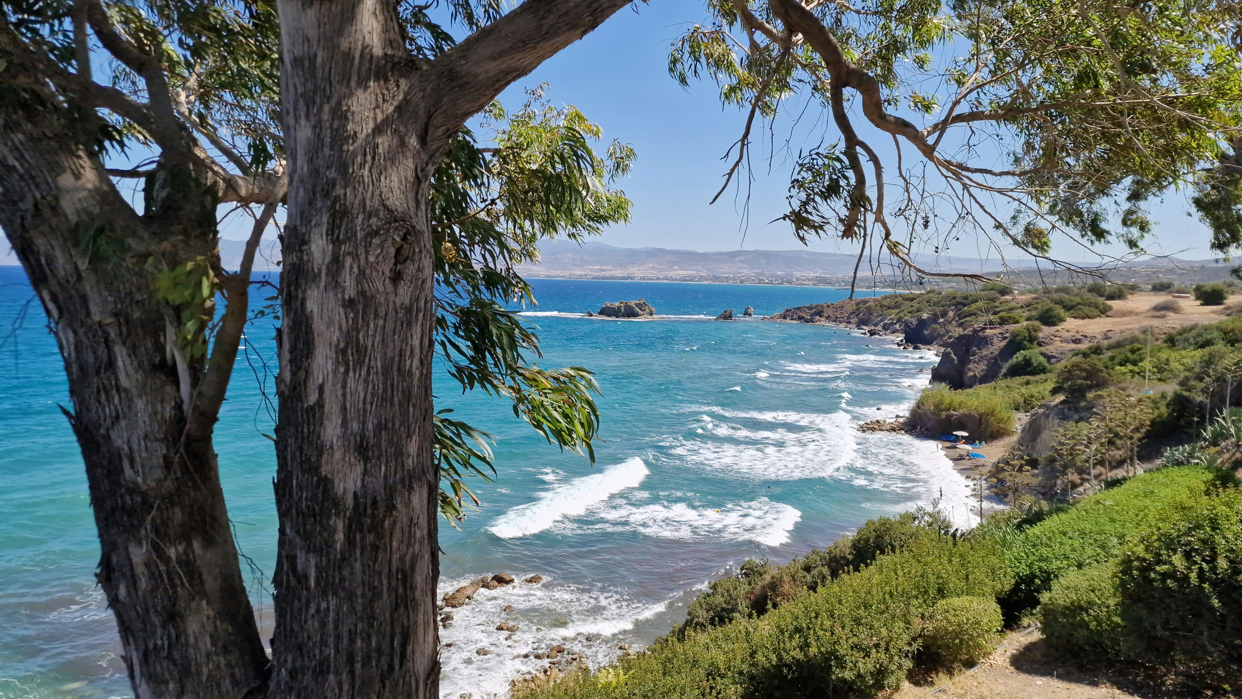 Rocky coastline with turquoise waves crashing ashore.