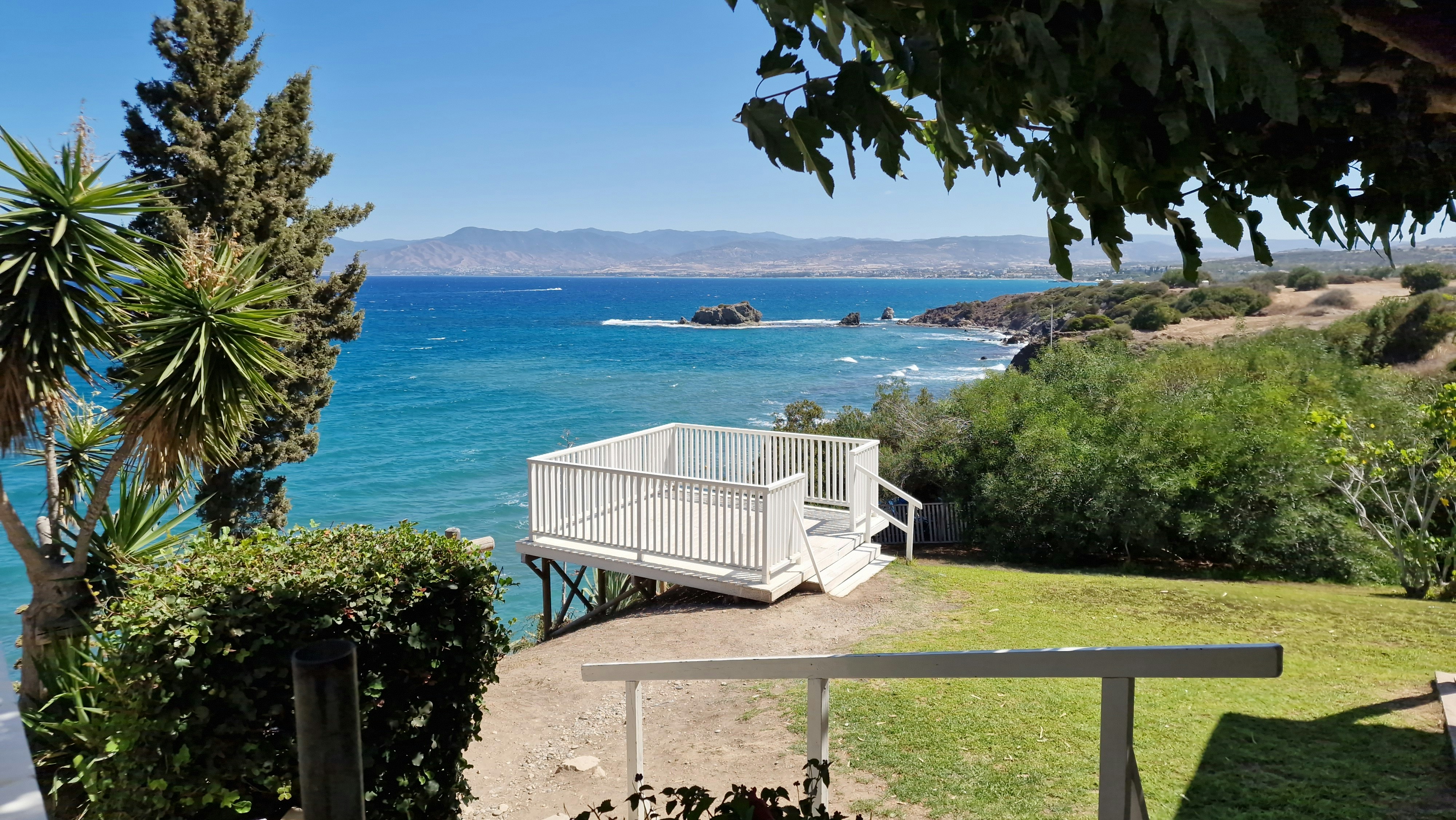 Deck overlooking a turquoise ocean and rocky coastline