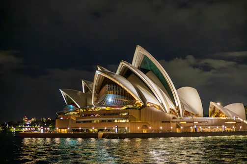 Sydney opera house at night with water reflections