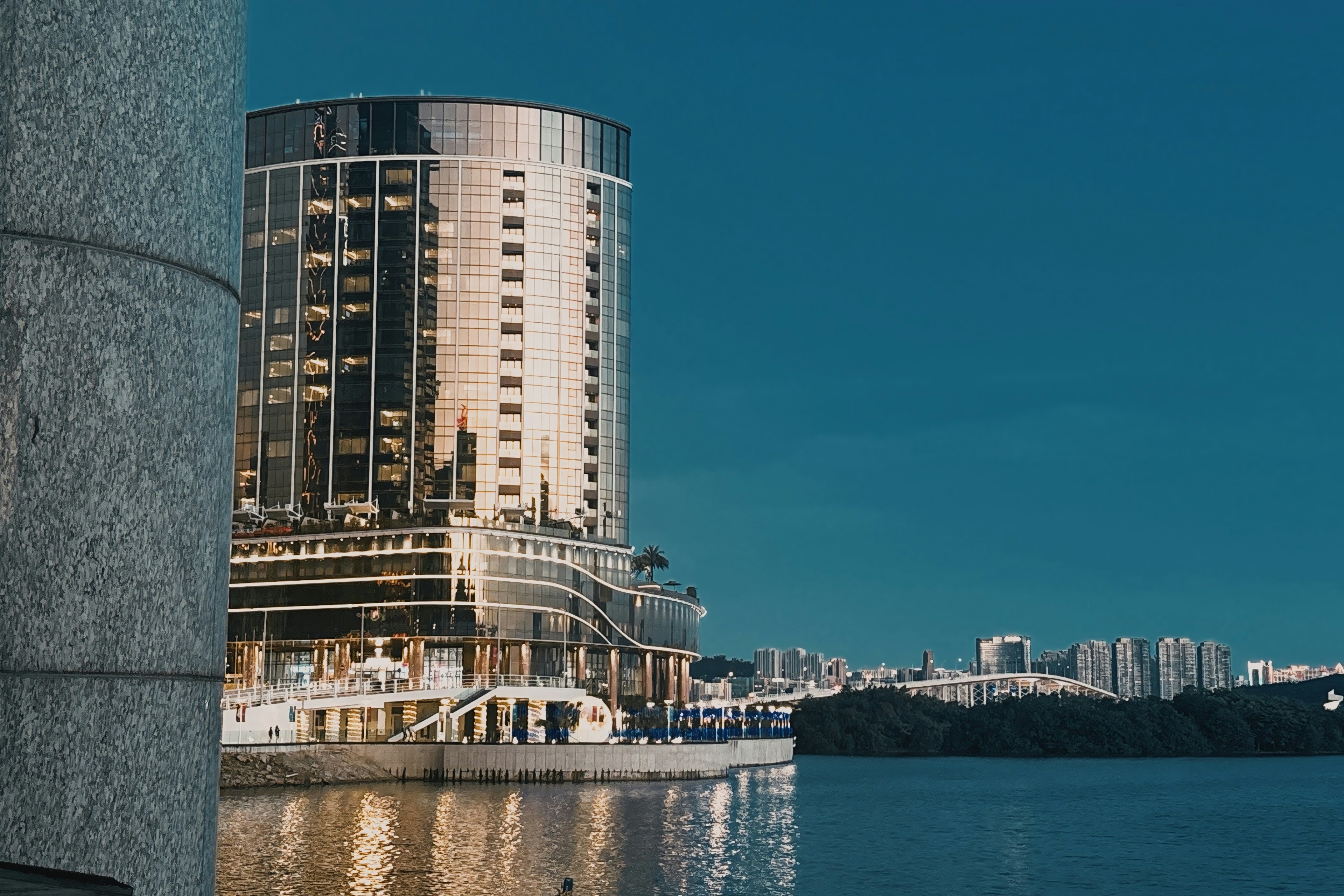 Modern hotel building by the water at sunset.