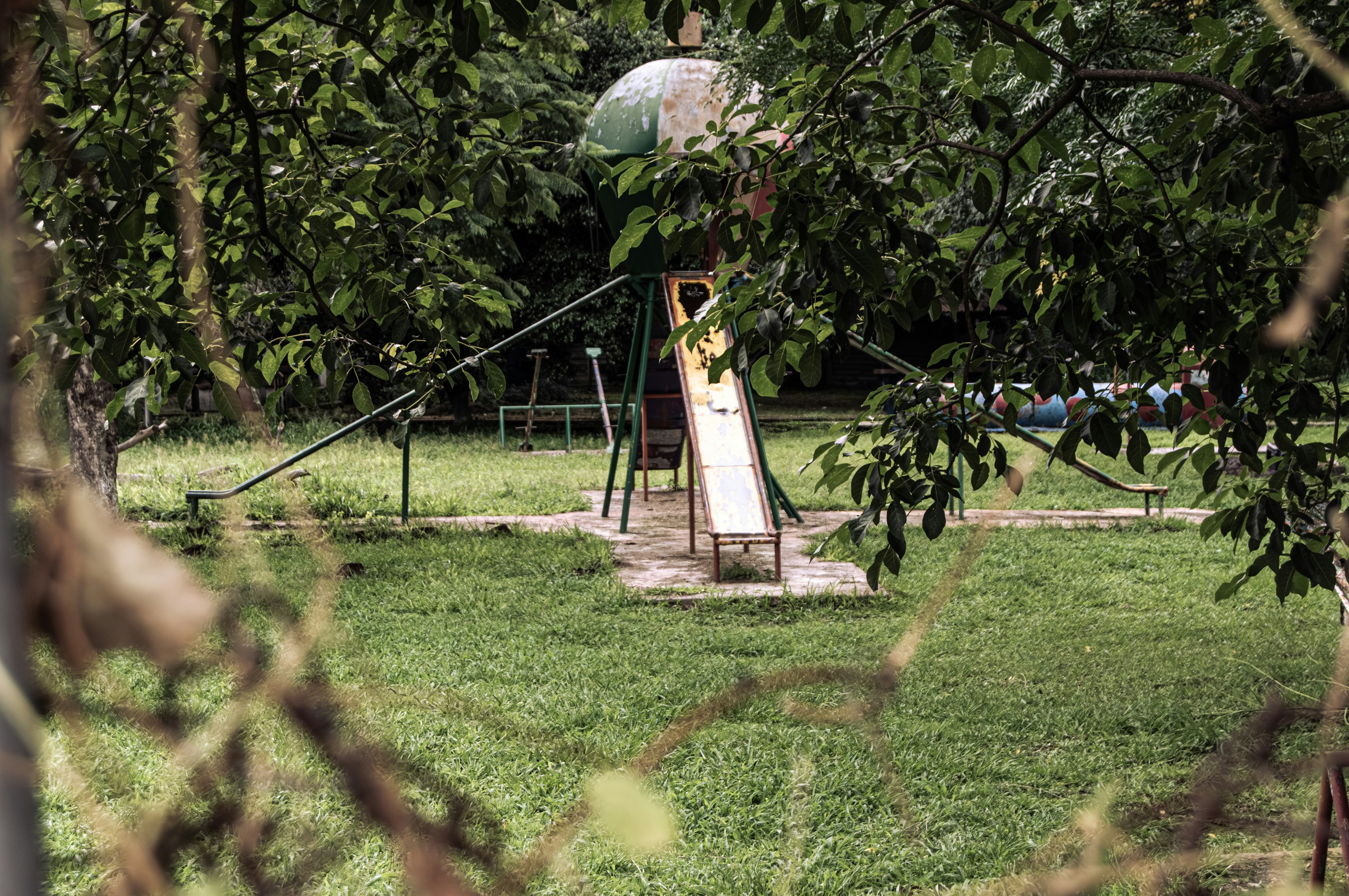 An old playground slide sits in a grassy yard.