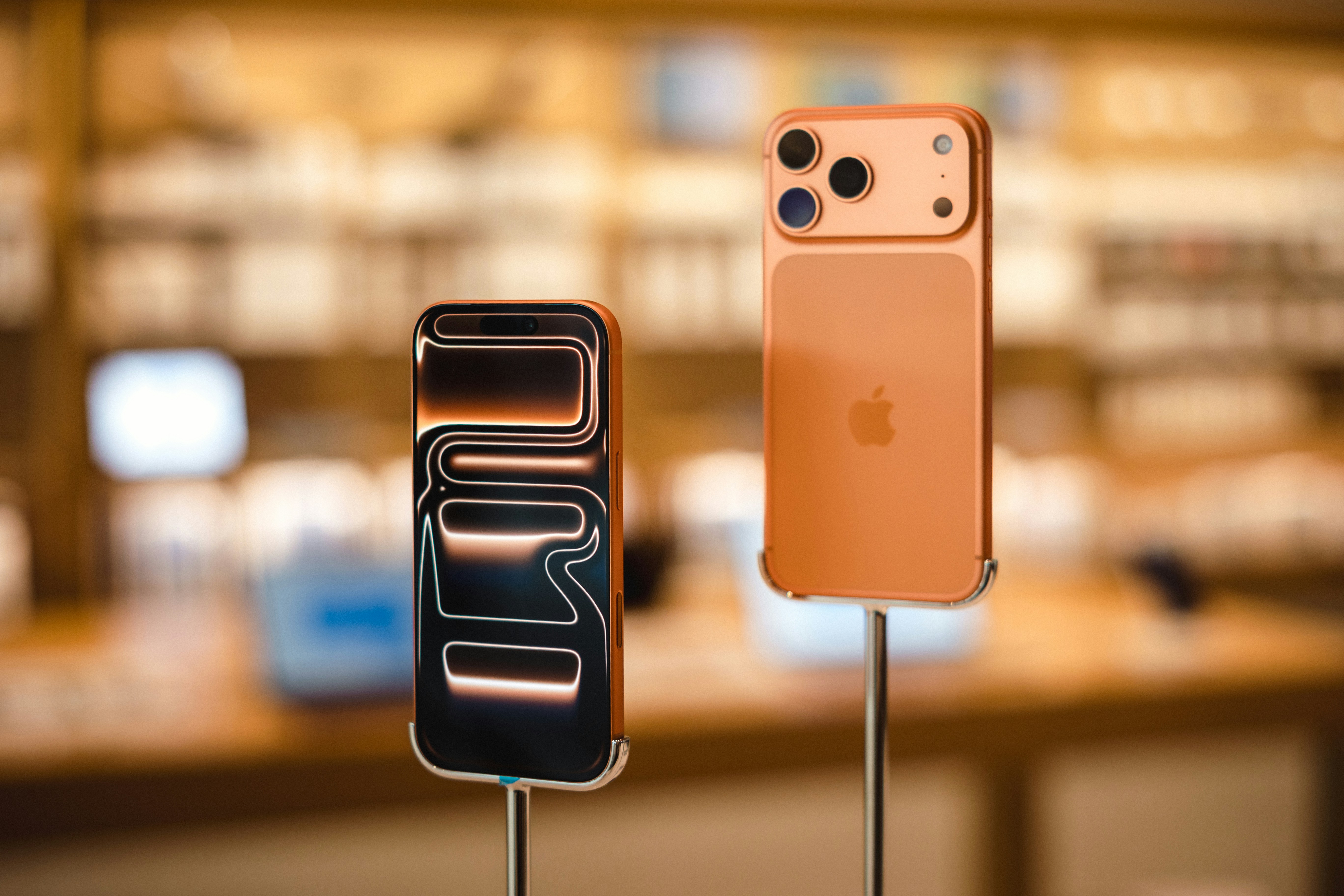 Two orange smartphones on display stands
