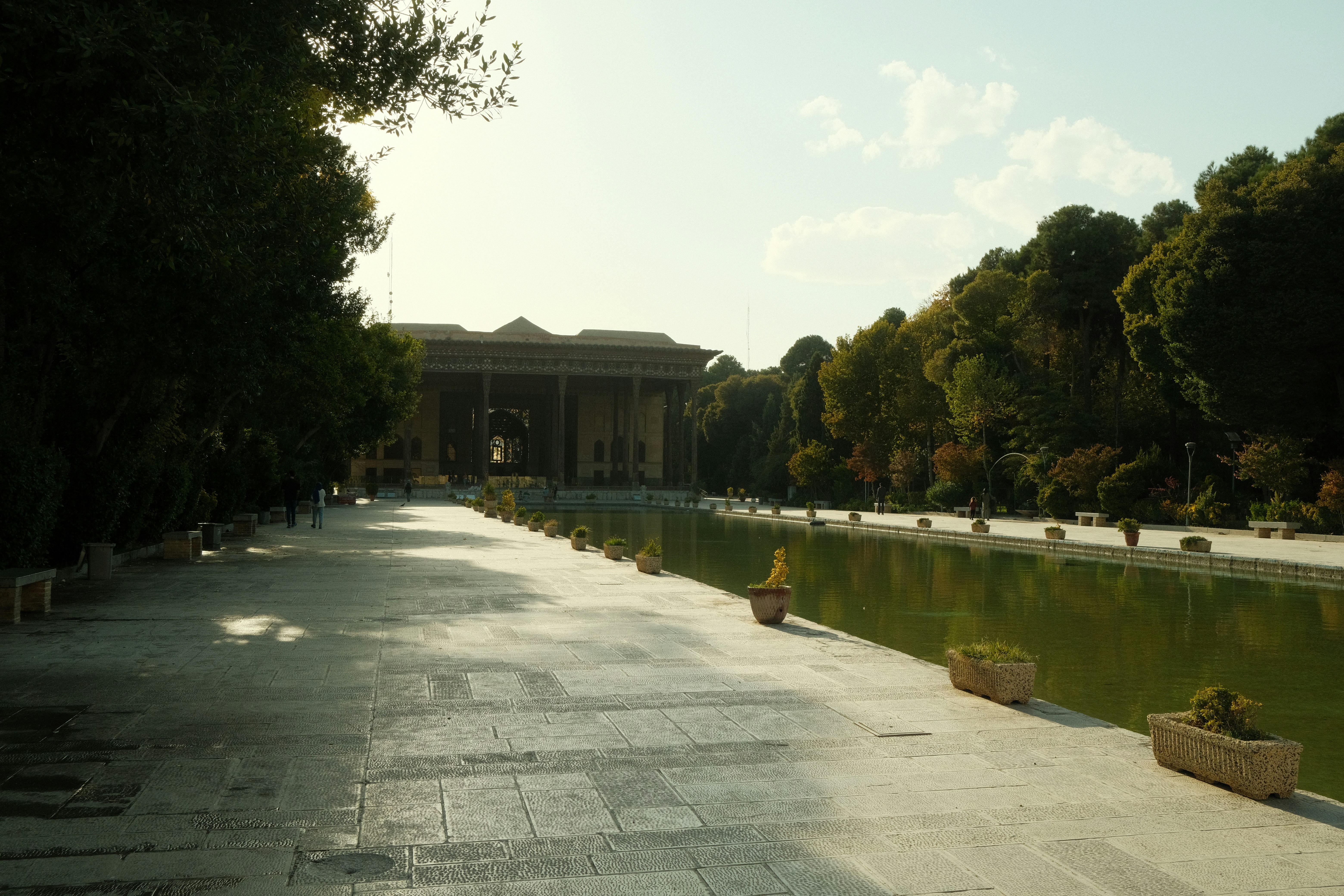 Grand palace with reflecting pool and manicured gardens.