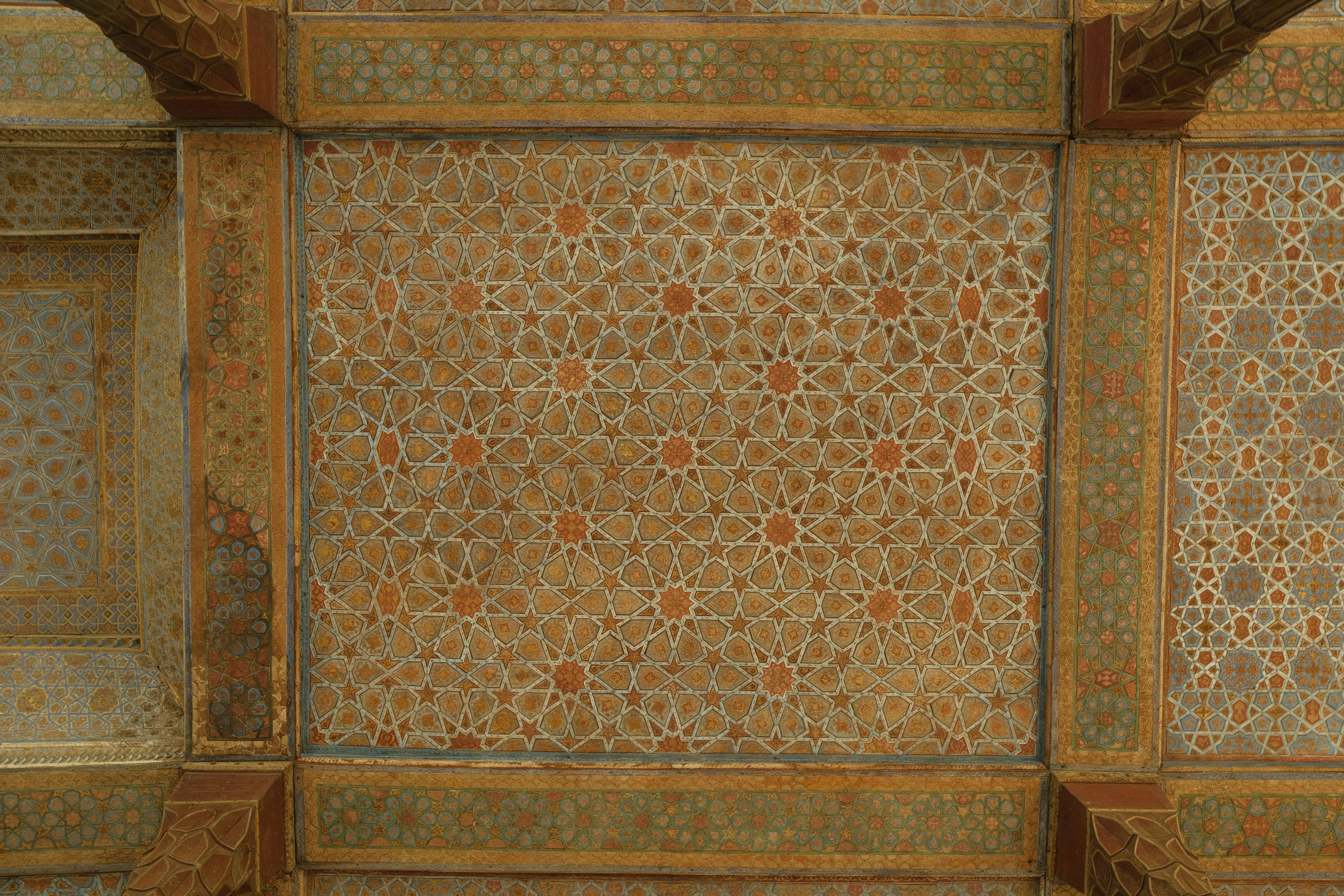 Intricate geometric patterns adorn an ornate ceiling.