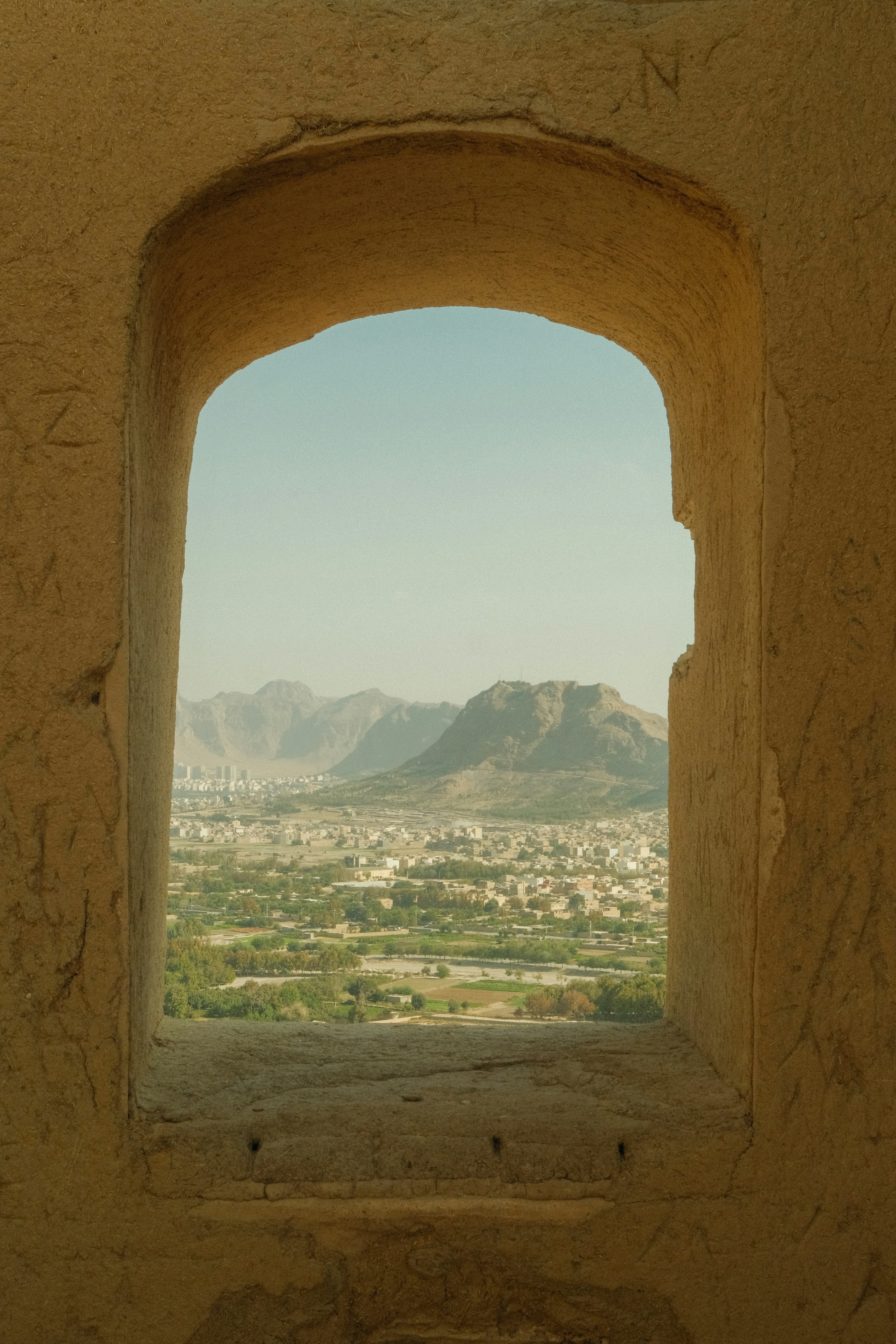 View of a city and mountains through an arched window