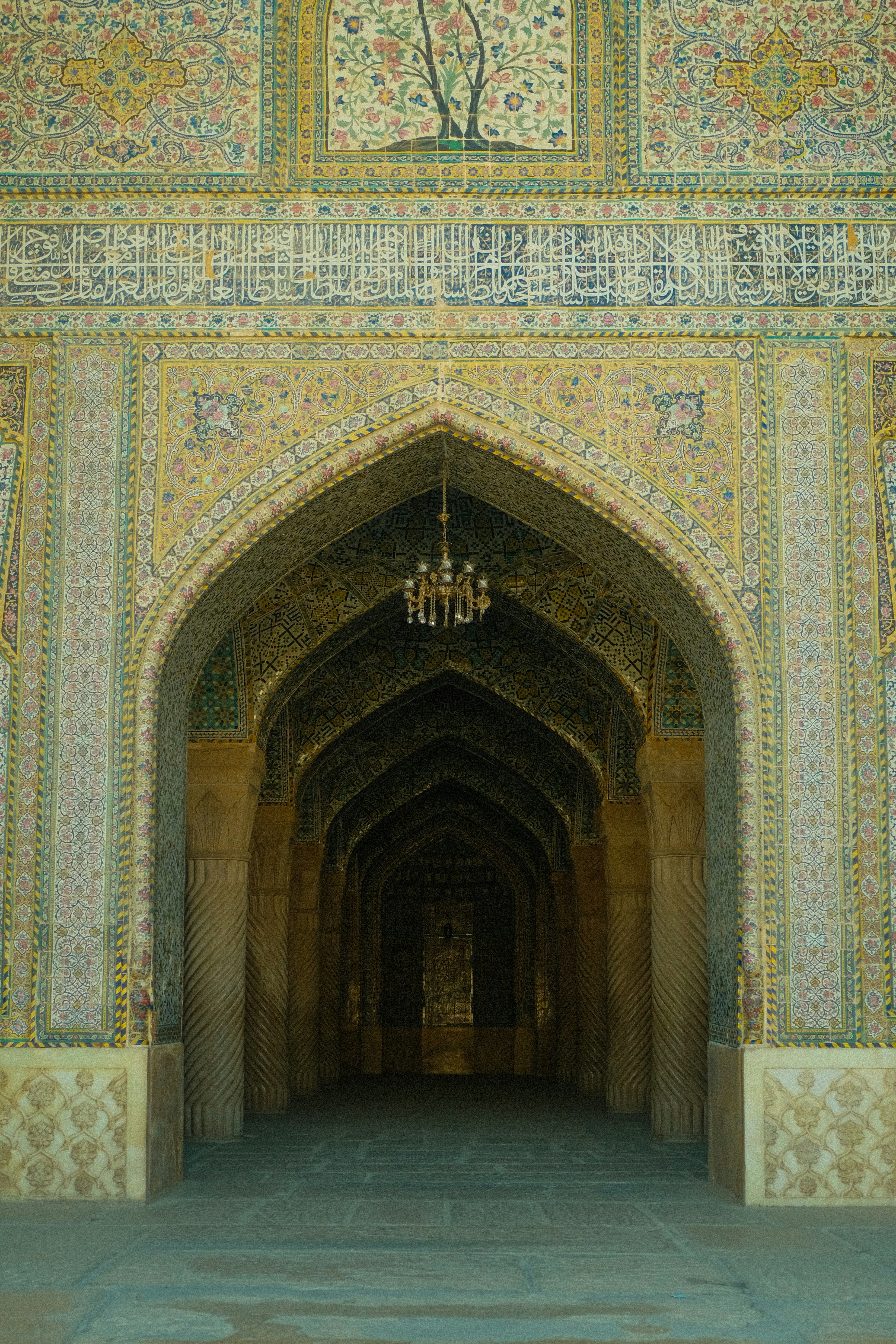 Ornate arched hallway with intricate tilework and calligraphy