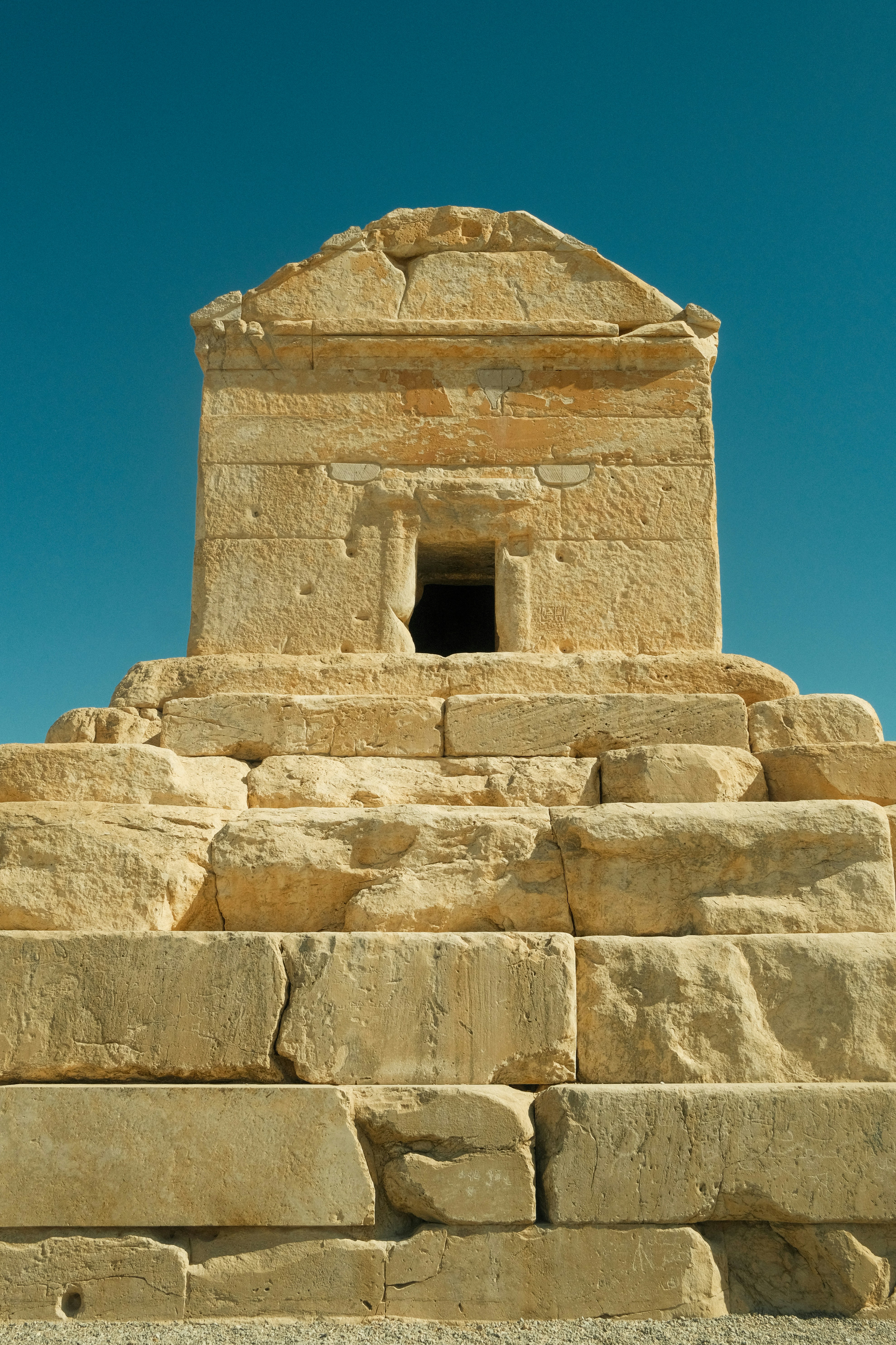 Ancient stone tomb against a clear blue sky
