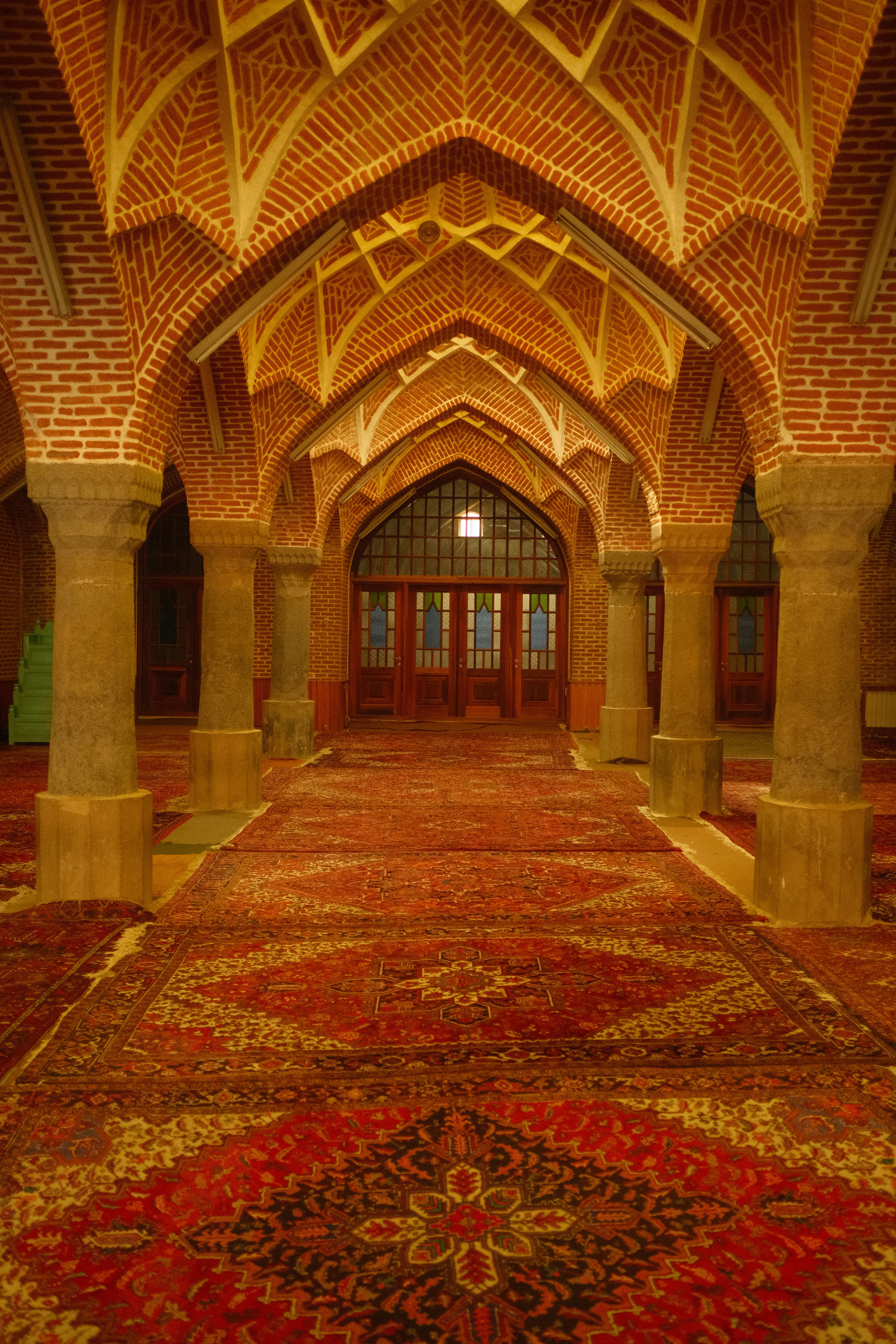 Arched hallway with ornate carpets and brick ceiling