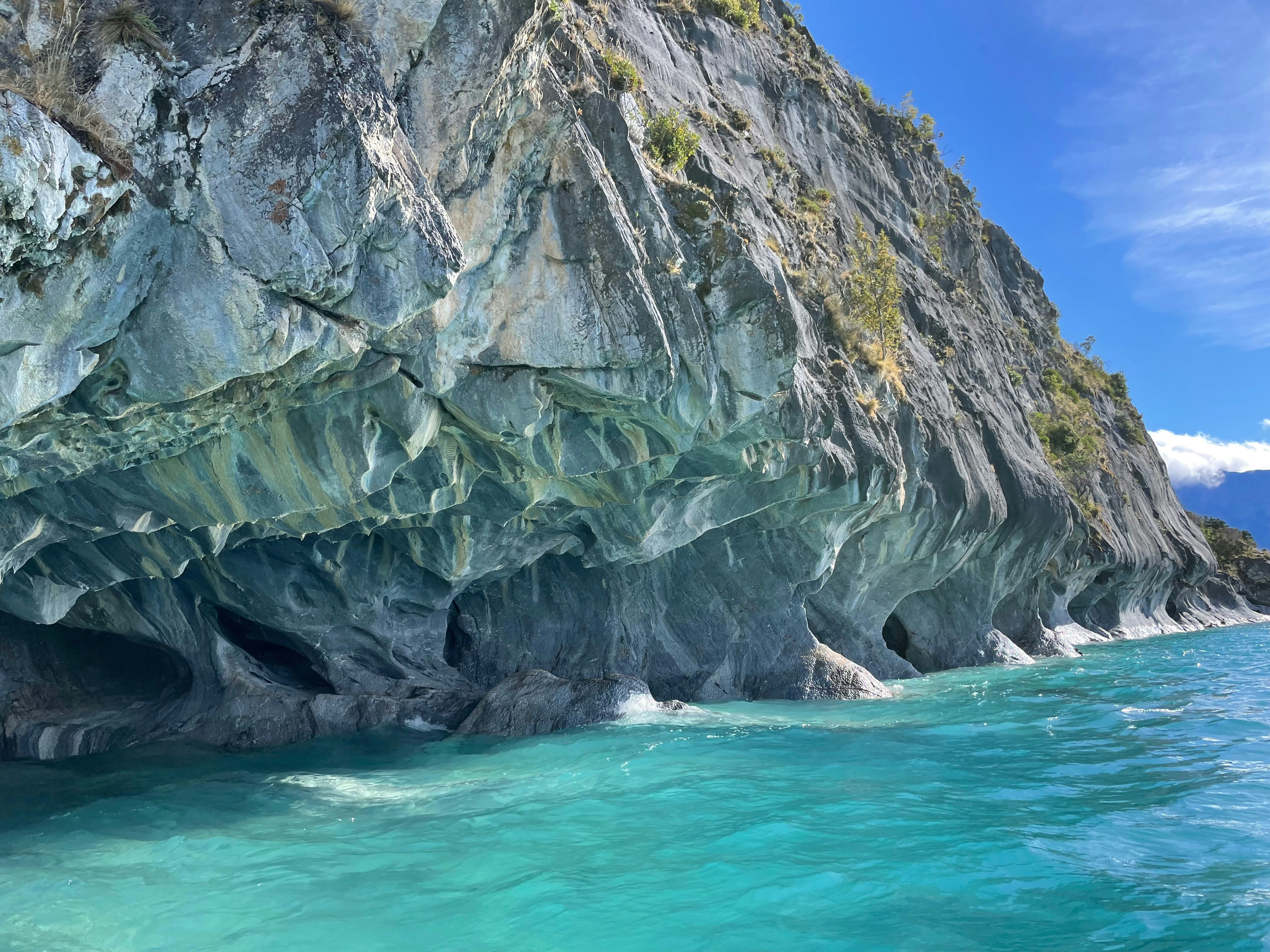 Turquoise water laps against sculpted marble caves.