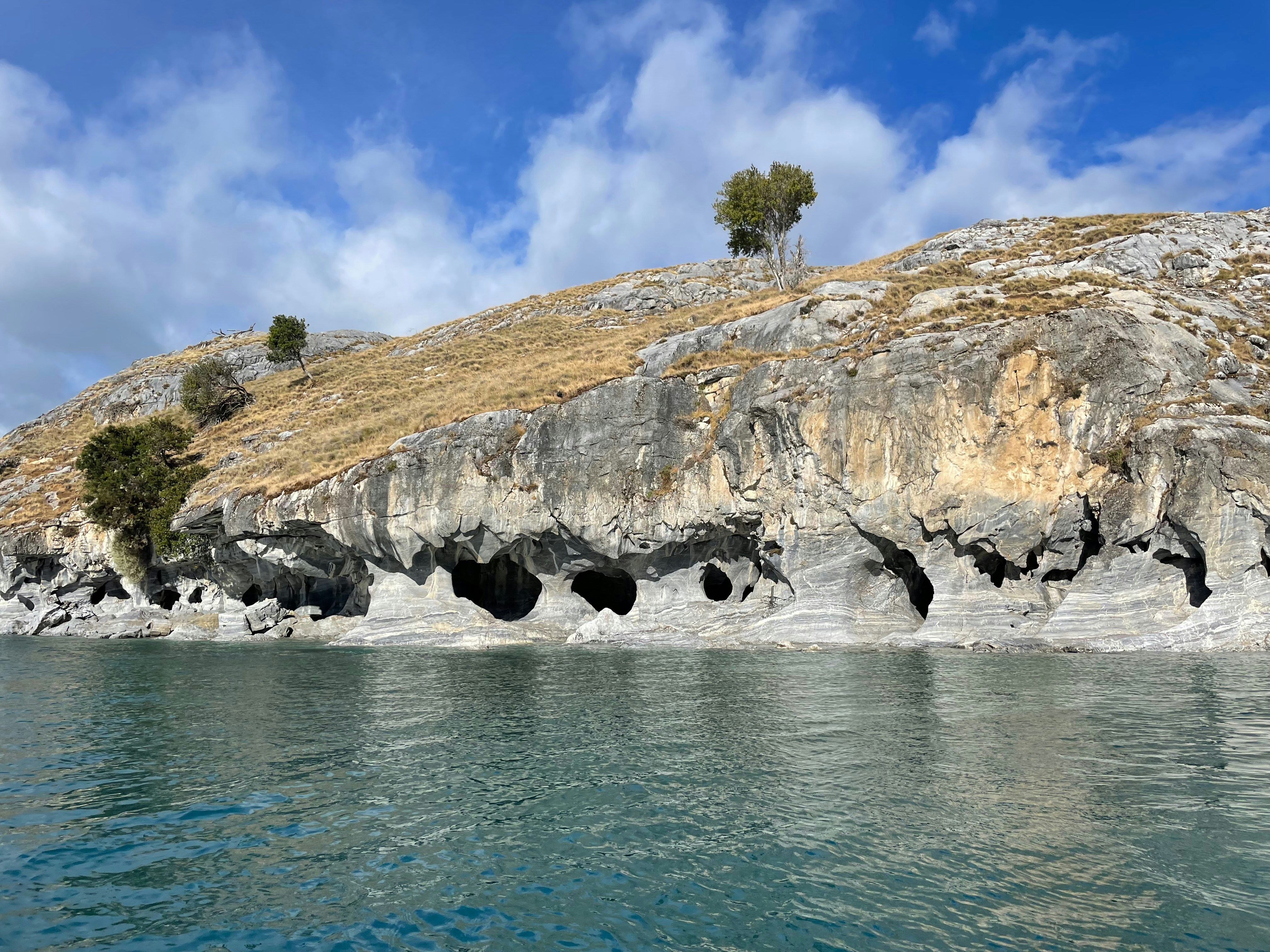 Water flowing into caves on a rocky cliffside.