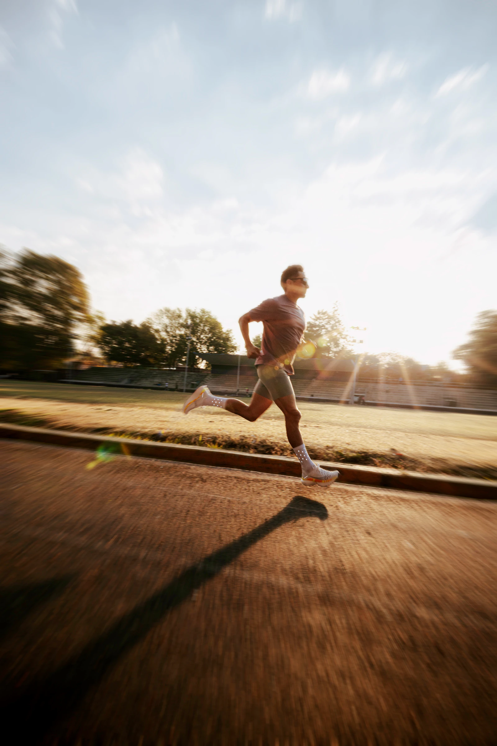 Runner training on an athletics track at sunrise