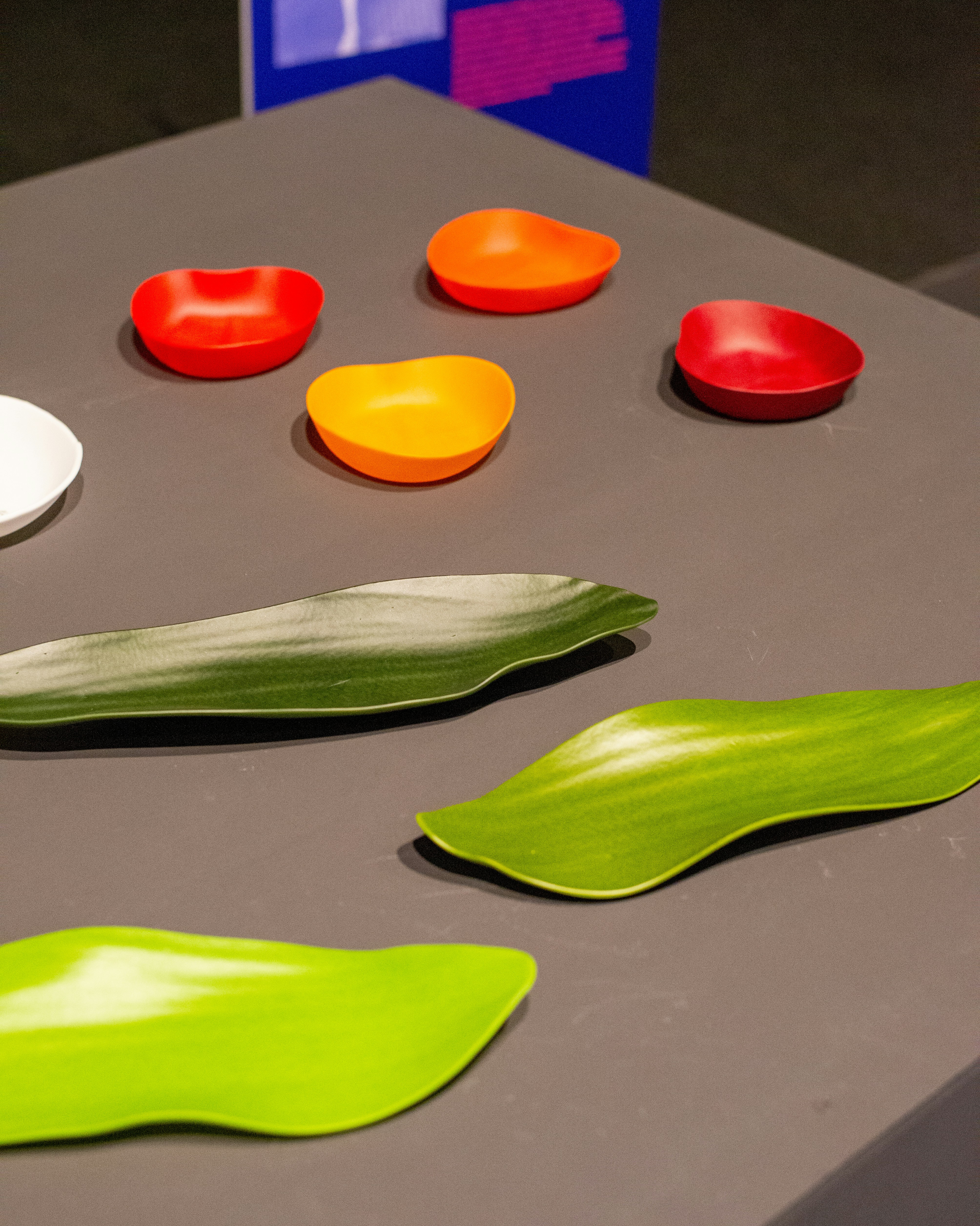 Colorful leaf-shaped dishes and small bowls arranged on a surface.