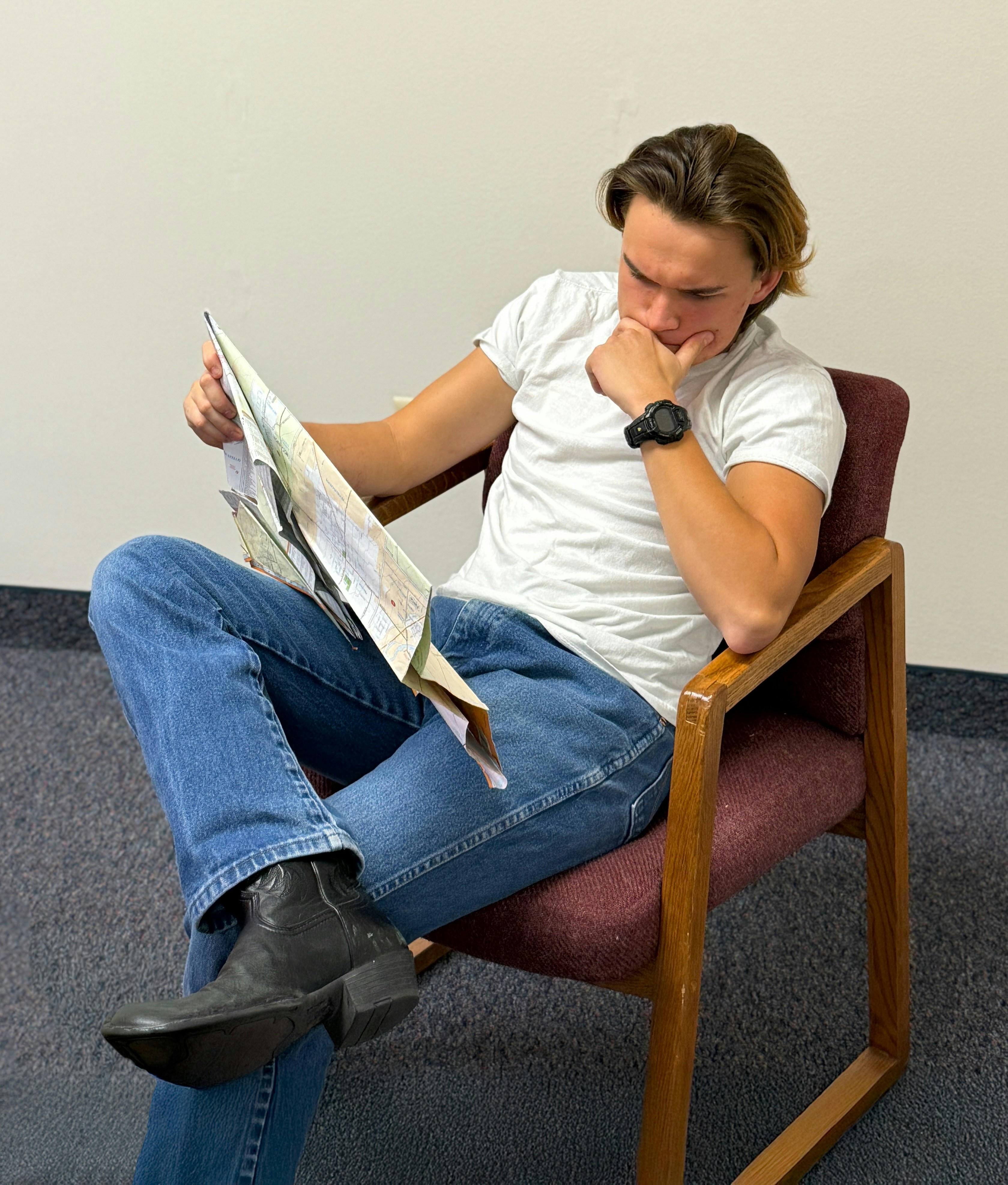 Young man sitting and reading a map