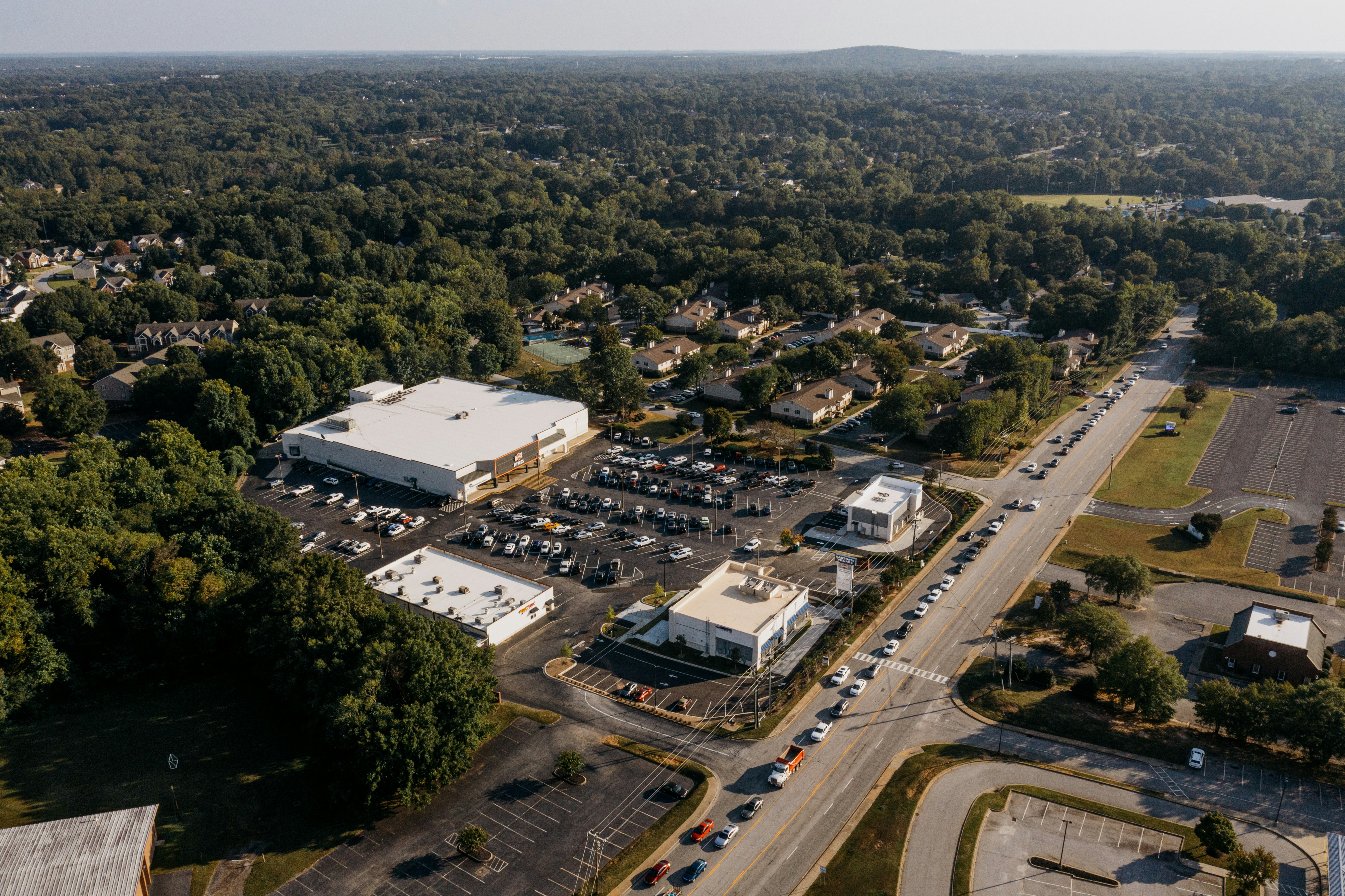 Aerial view of a suburban commercial area with parking lots.