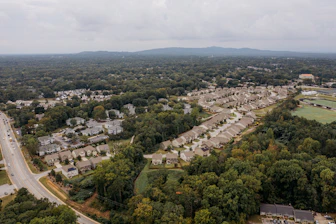 Aerial view of a suburban neighborhood with dense trees.