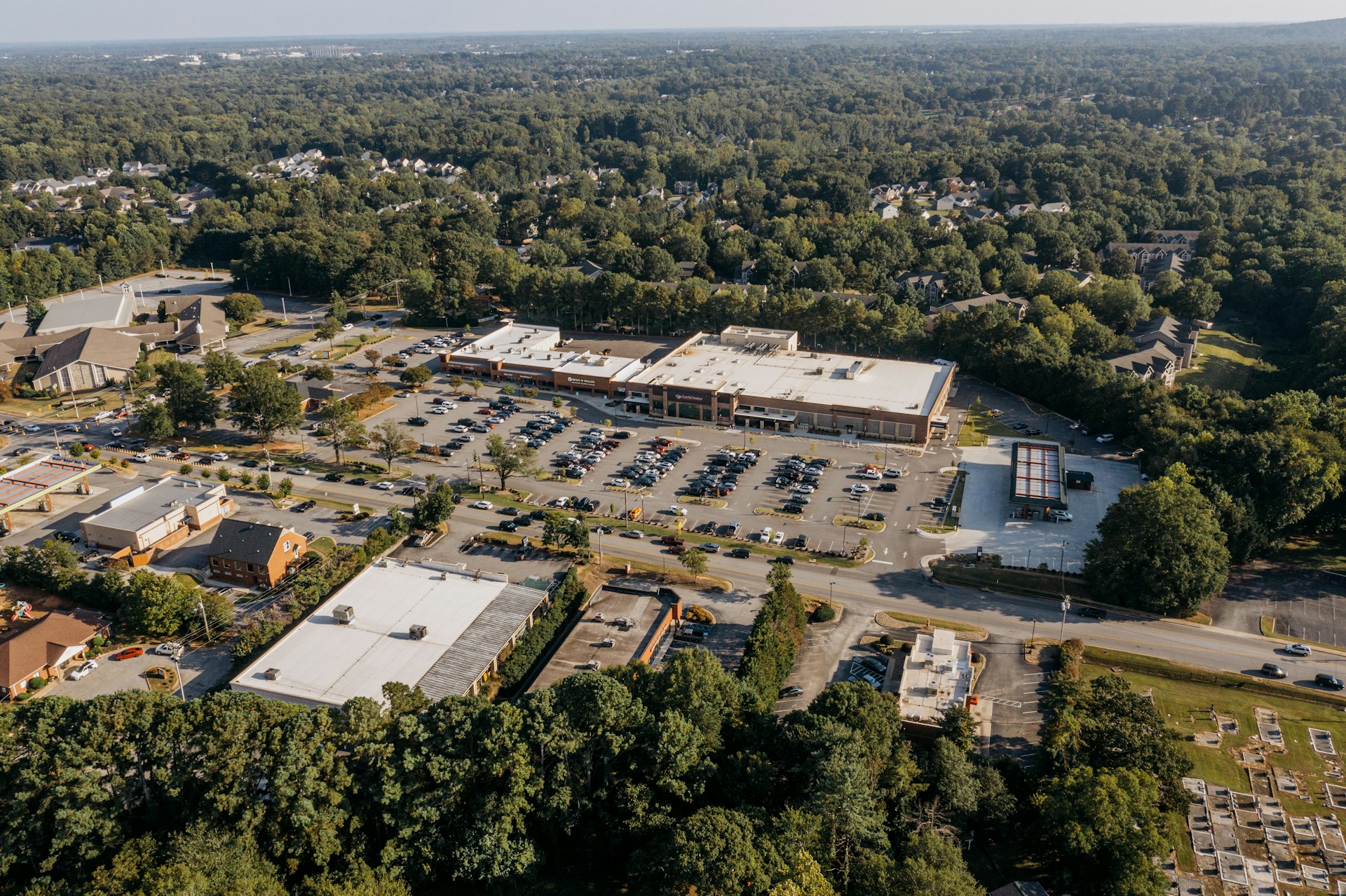 Aerial view of a suburban shopping center surrounded by trees