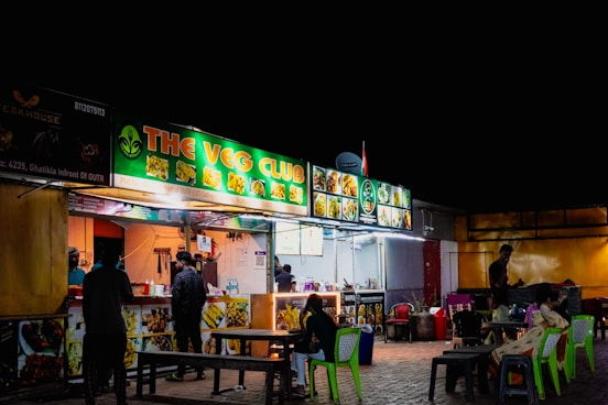 Street food stalls at night with people eating area lights