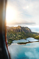 Aerial view of lush green mountains and turquoise ocean