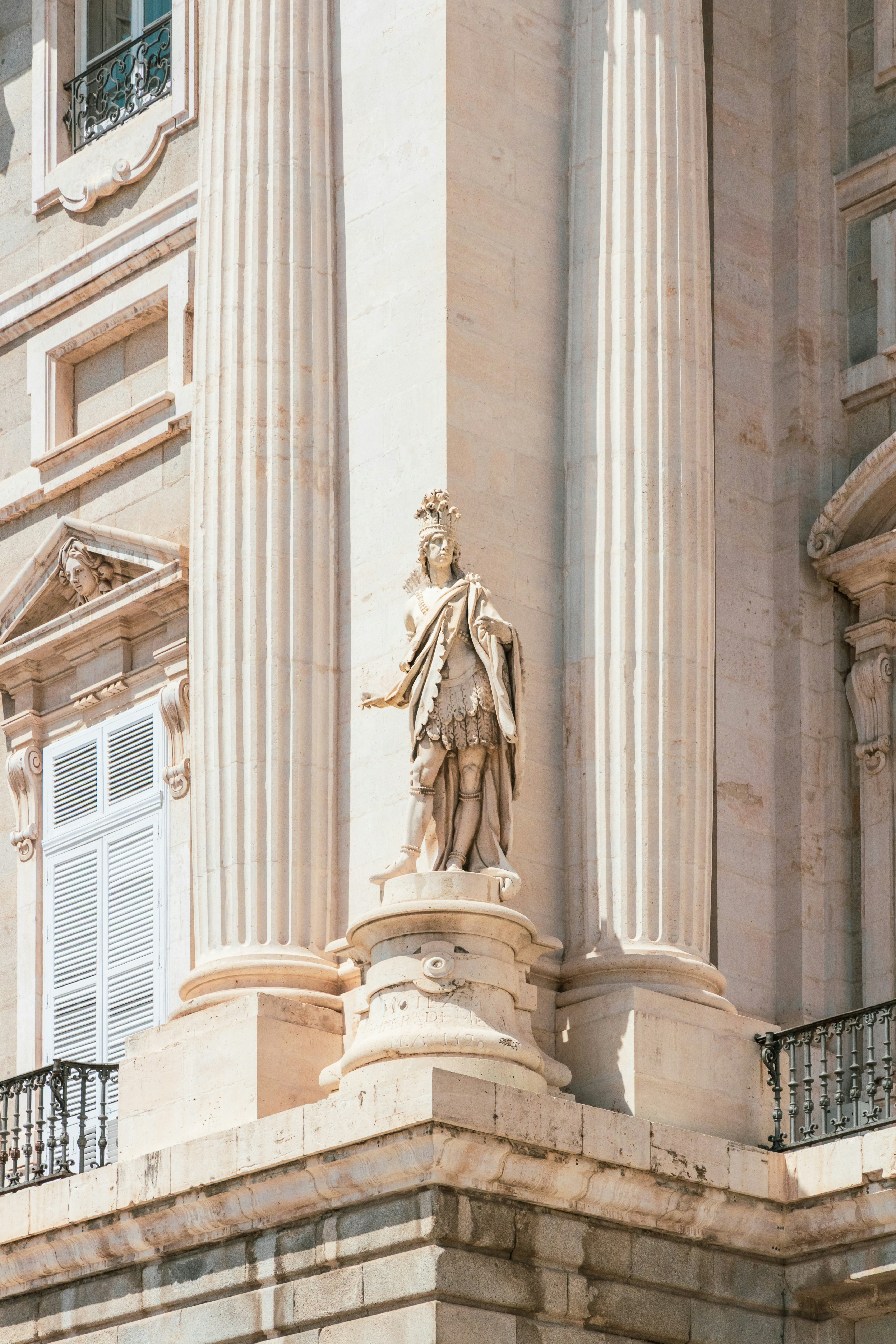 Statue between large columns of ornate building