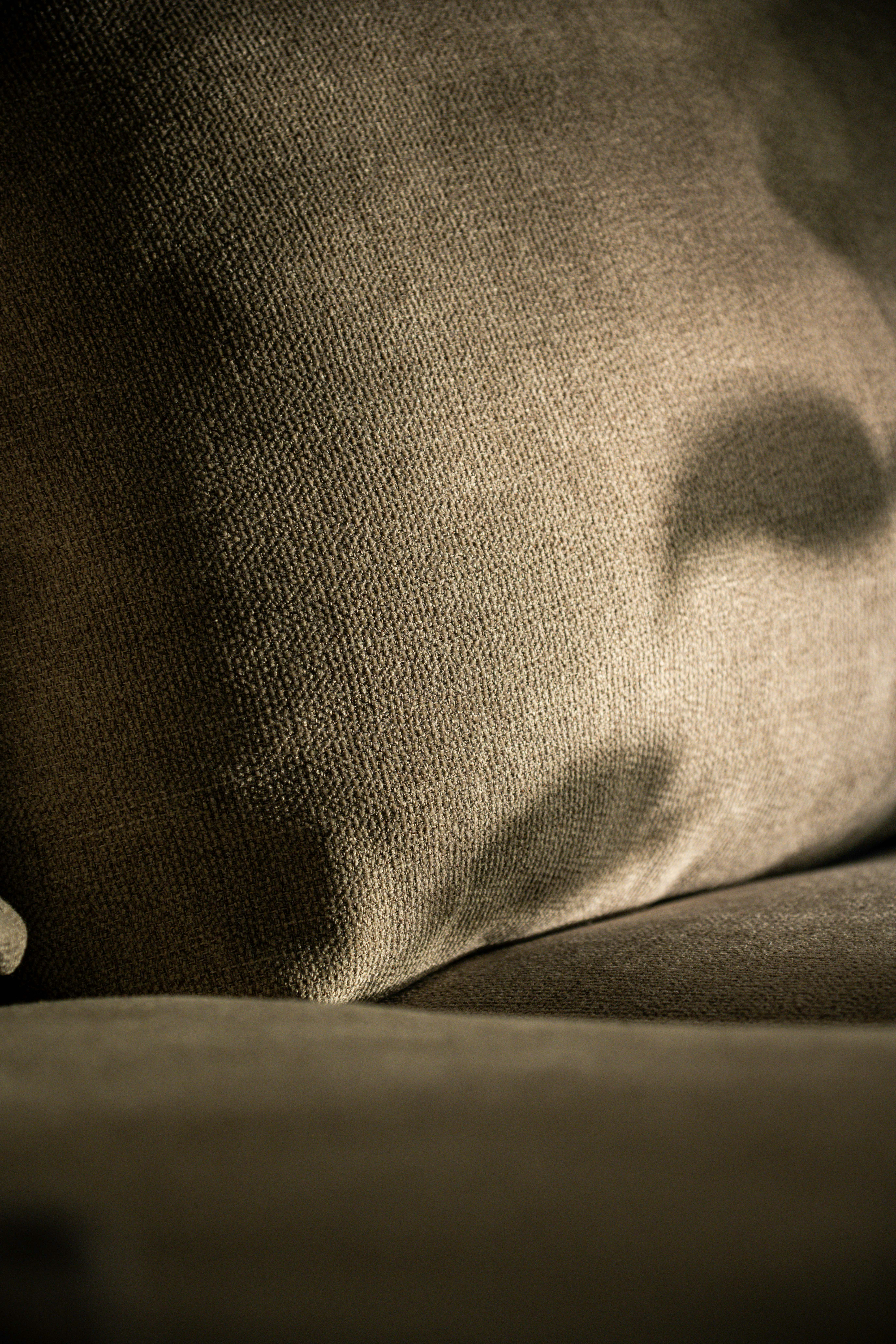 Close-up of a textured brown fabric cushion with shadows.