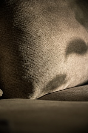 Close-up of a textured brown fabric cushion with shadows.