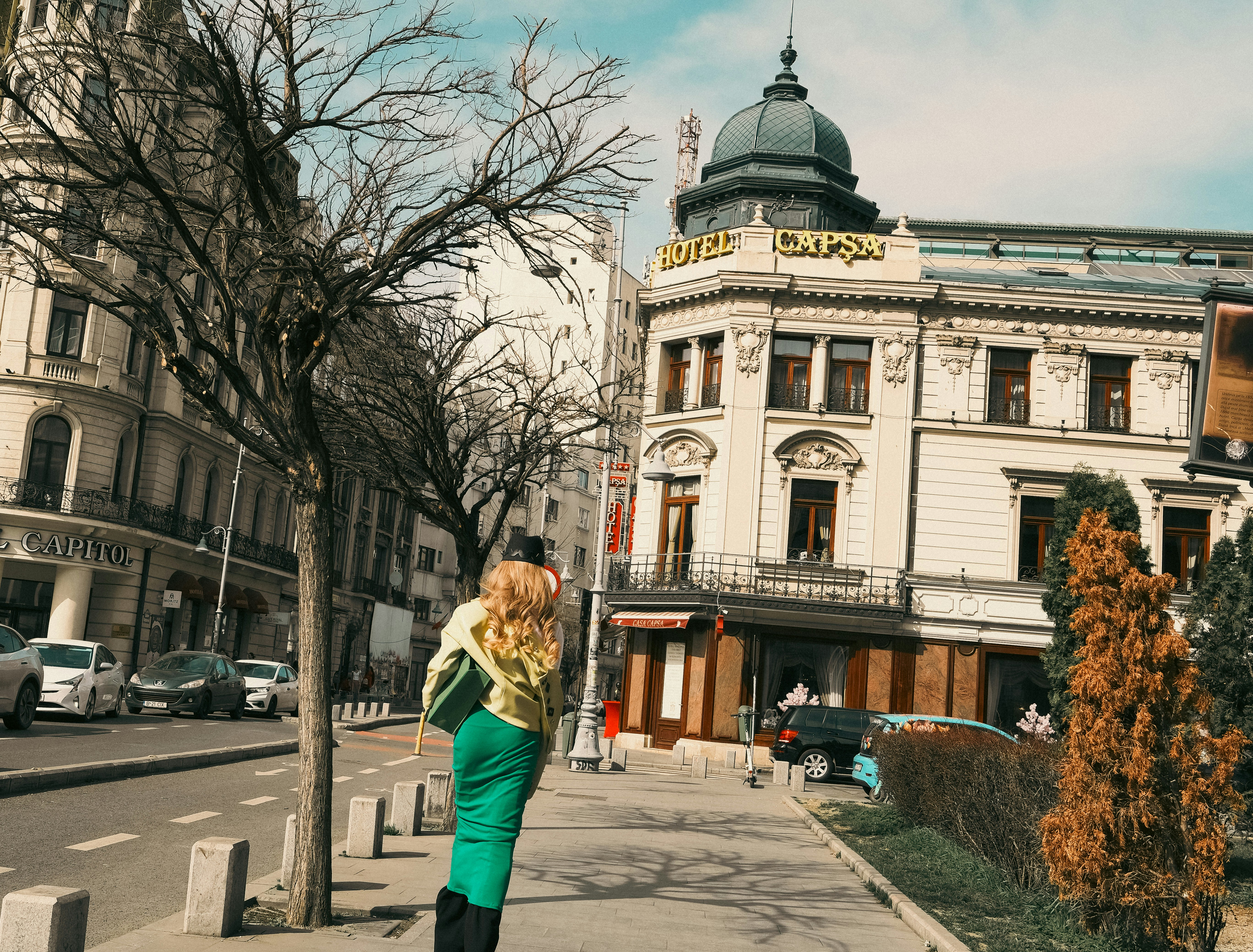 Woman walking on sidewalk with buildings behind.