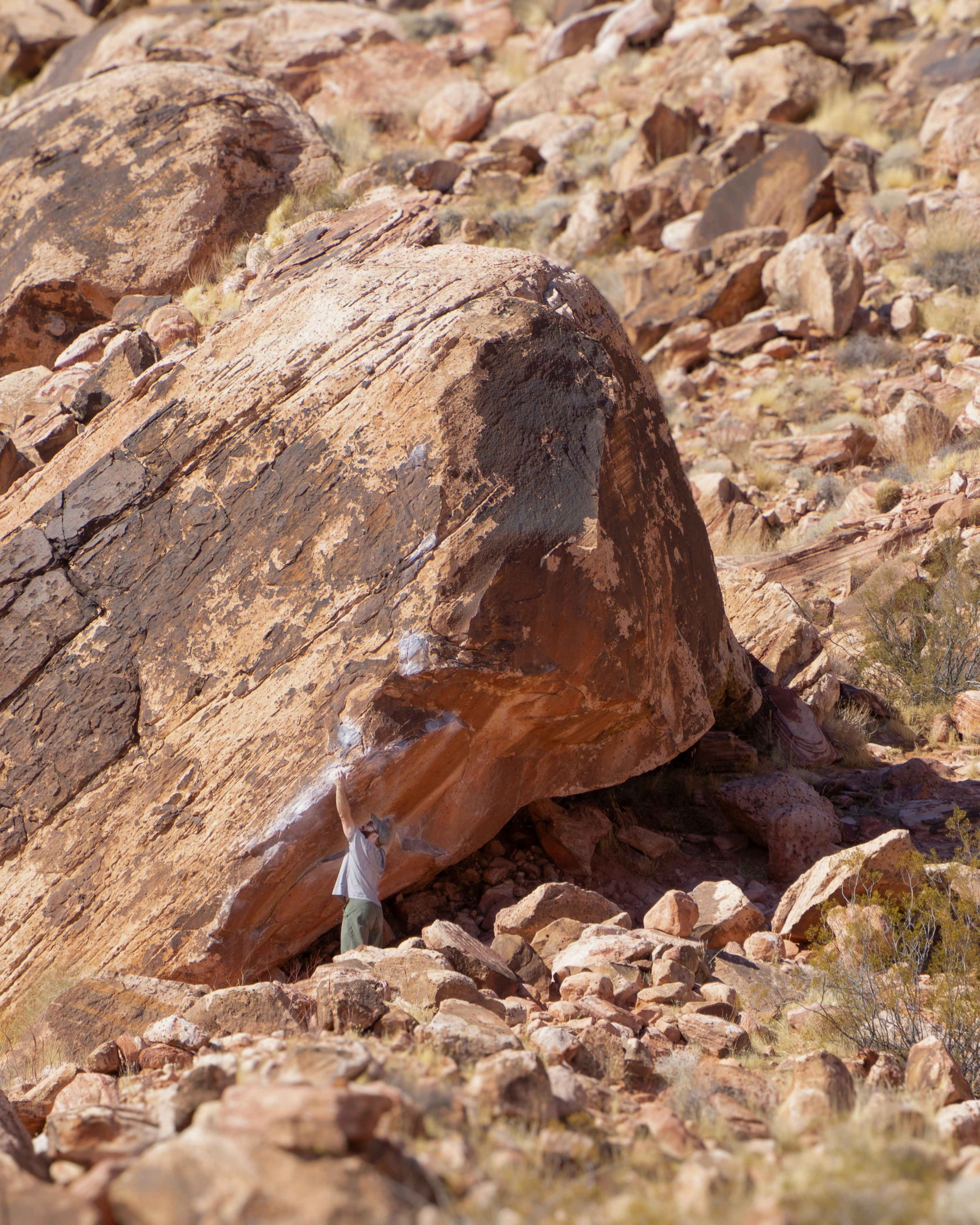 Person stands under a large rock formation.