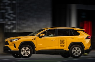 Yellow taxi car driving on a city street