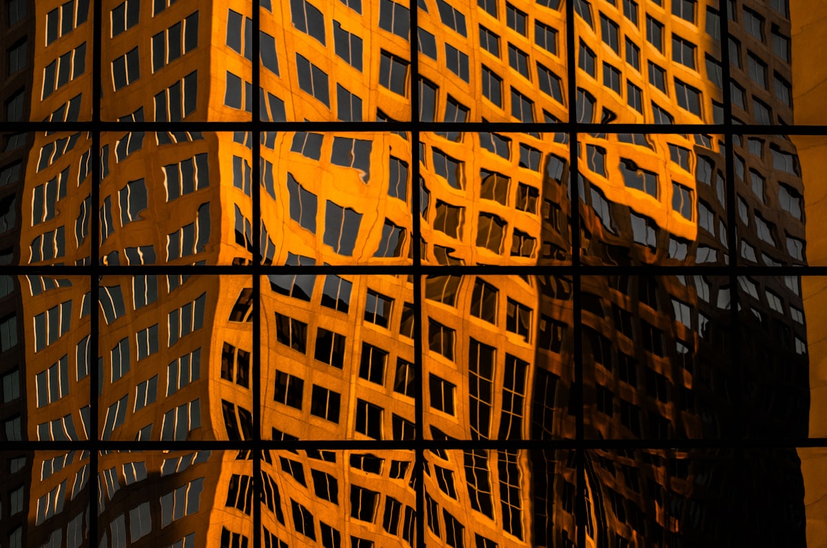 Golden building reflection on a glass facade, architectural economic-weight register