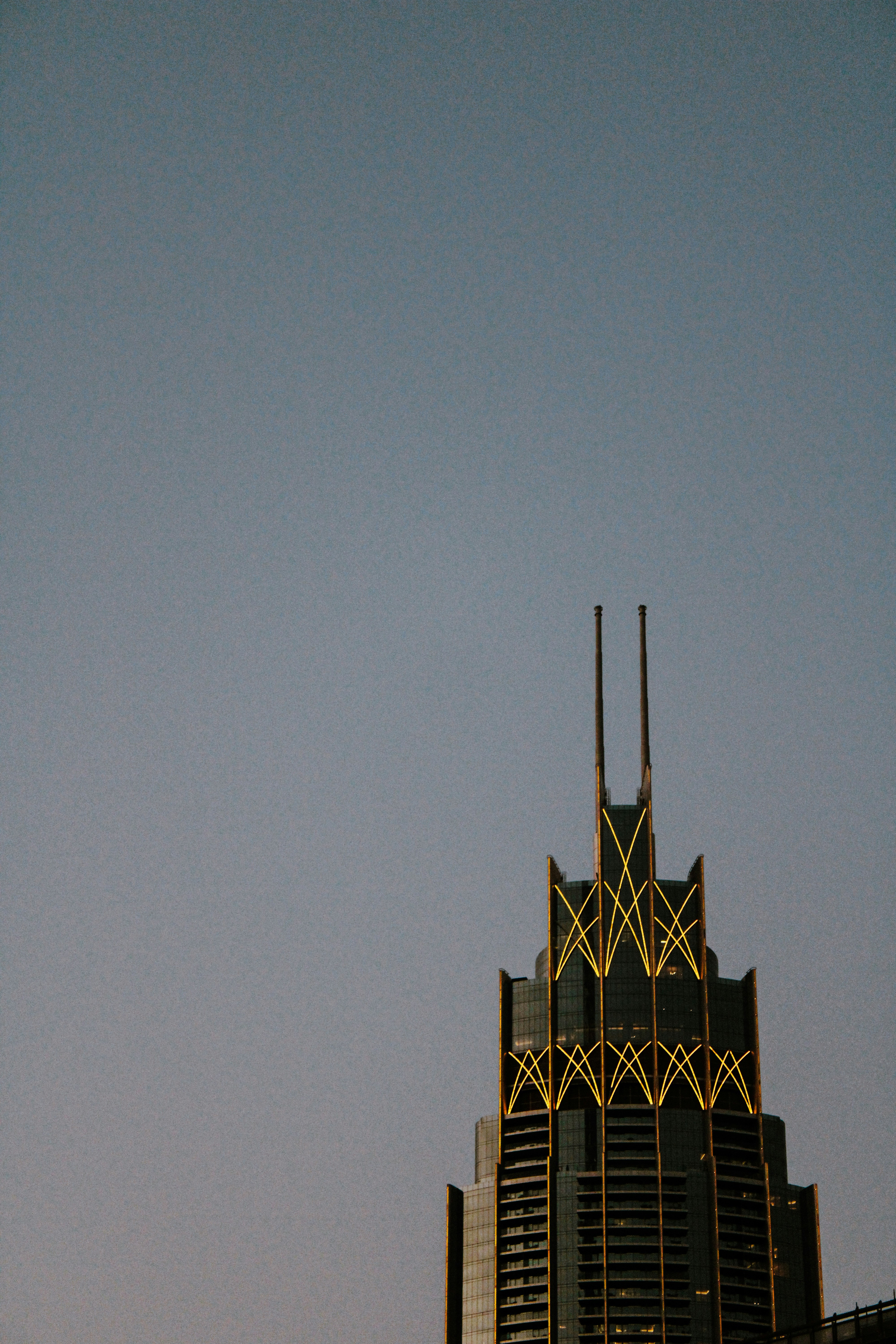 Art deco skyscraper illuminated against twilight sky
