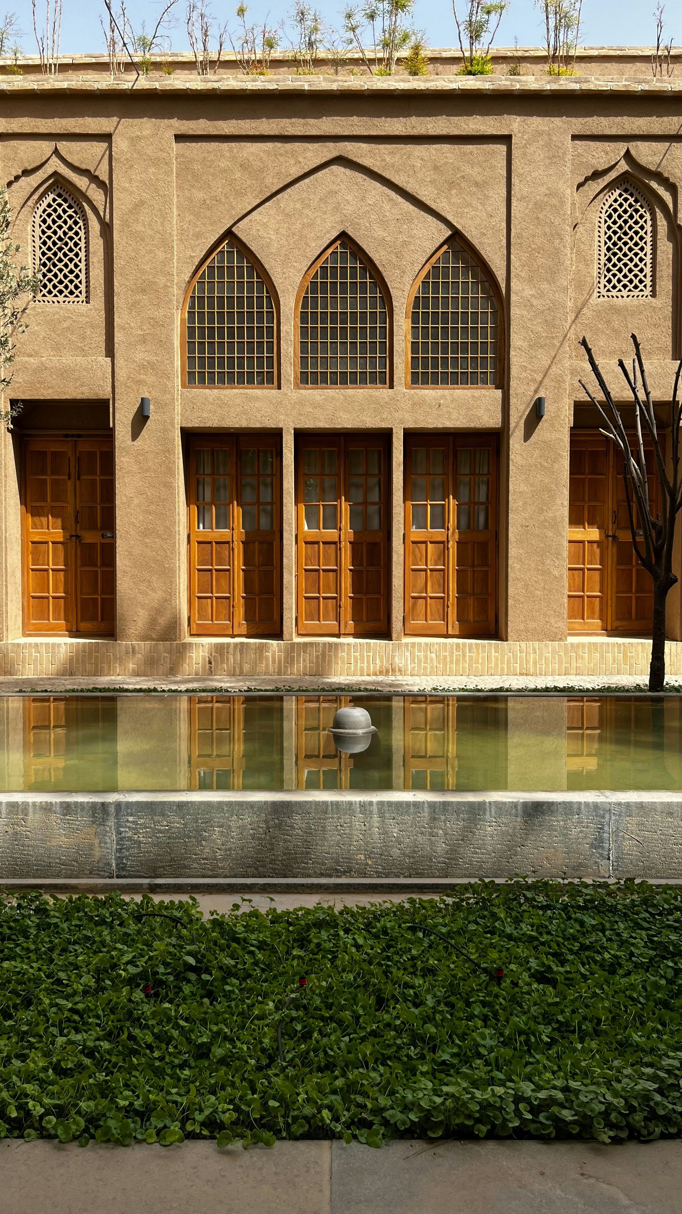 Edificio tradizionale con finestre ad arco e riflessione della piscina