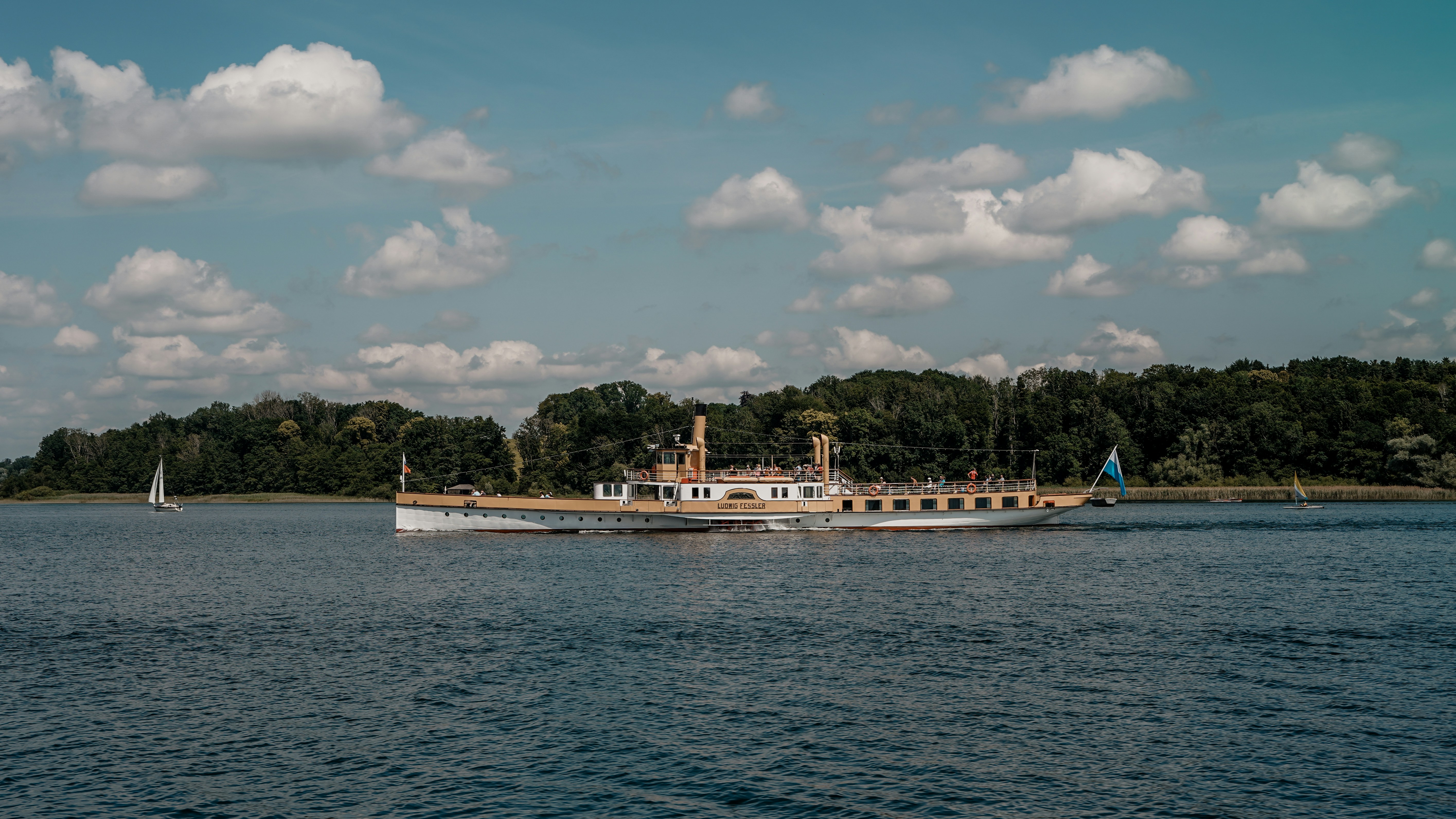 A large steamboat sails on a blue lake.