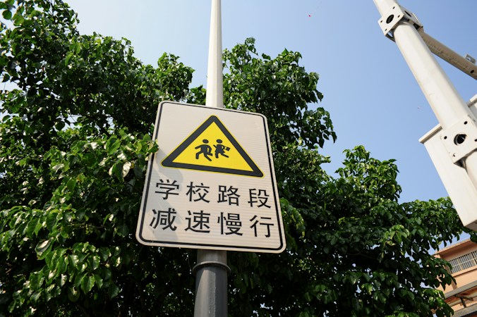 A yellow school zone warning sign with a children pictogram, a reminder to slow down near Clark County schools