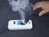 Electrical power strip smoking and sparking with hand nearby