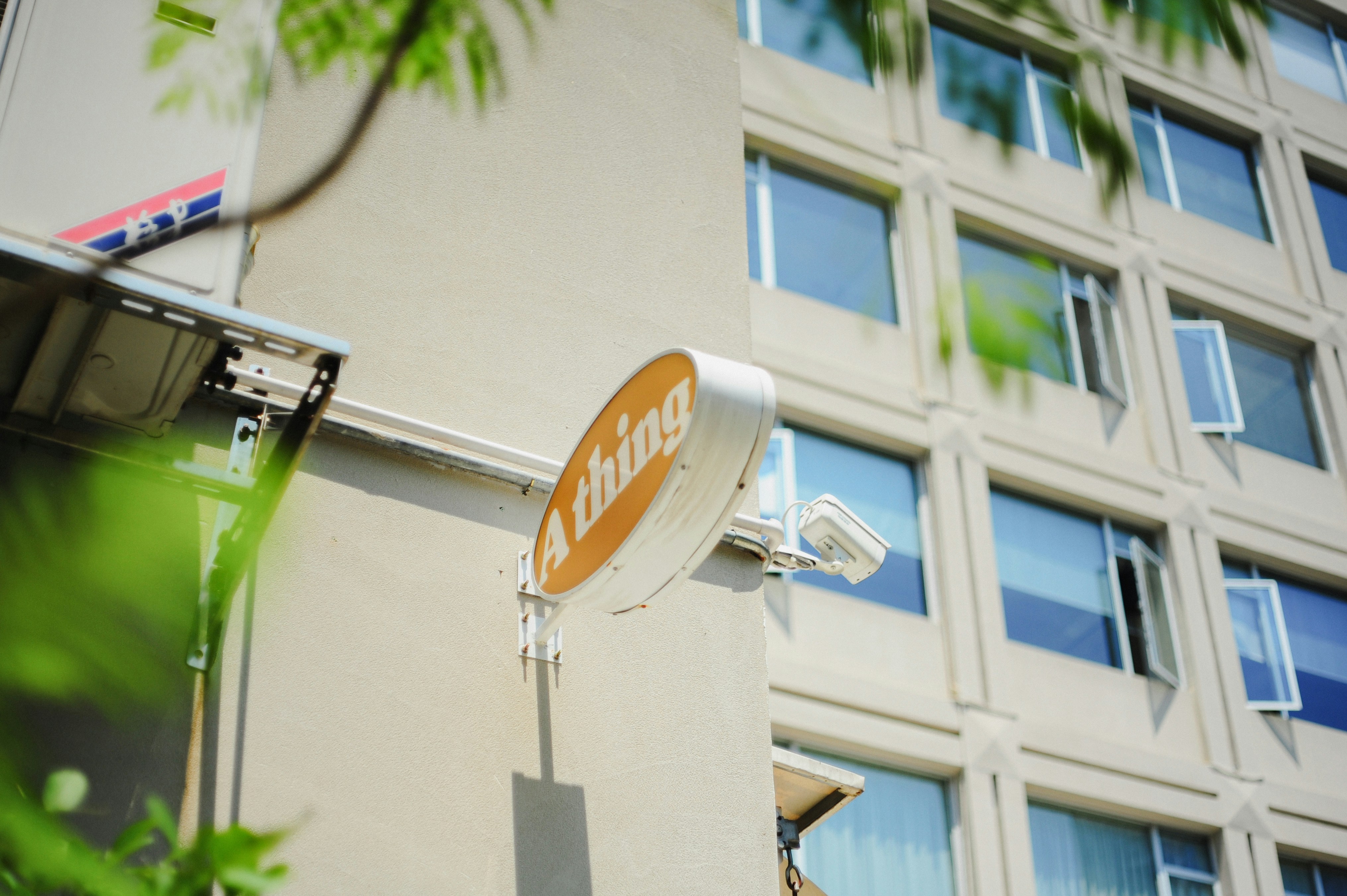 Edificio con letrero circular y hojas verdes