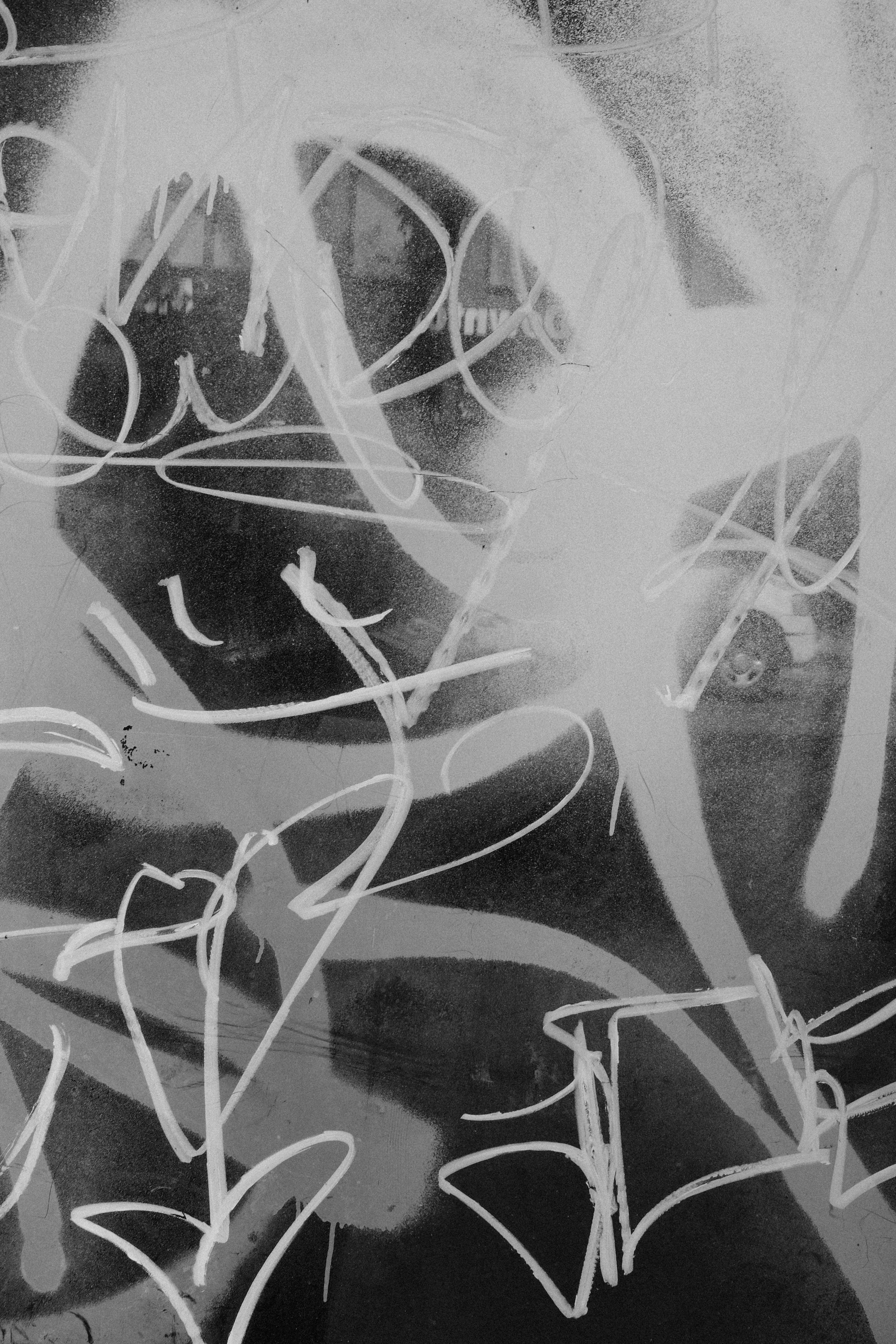 Abstract white graffiti tags on a dark background.