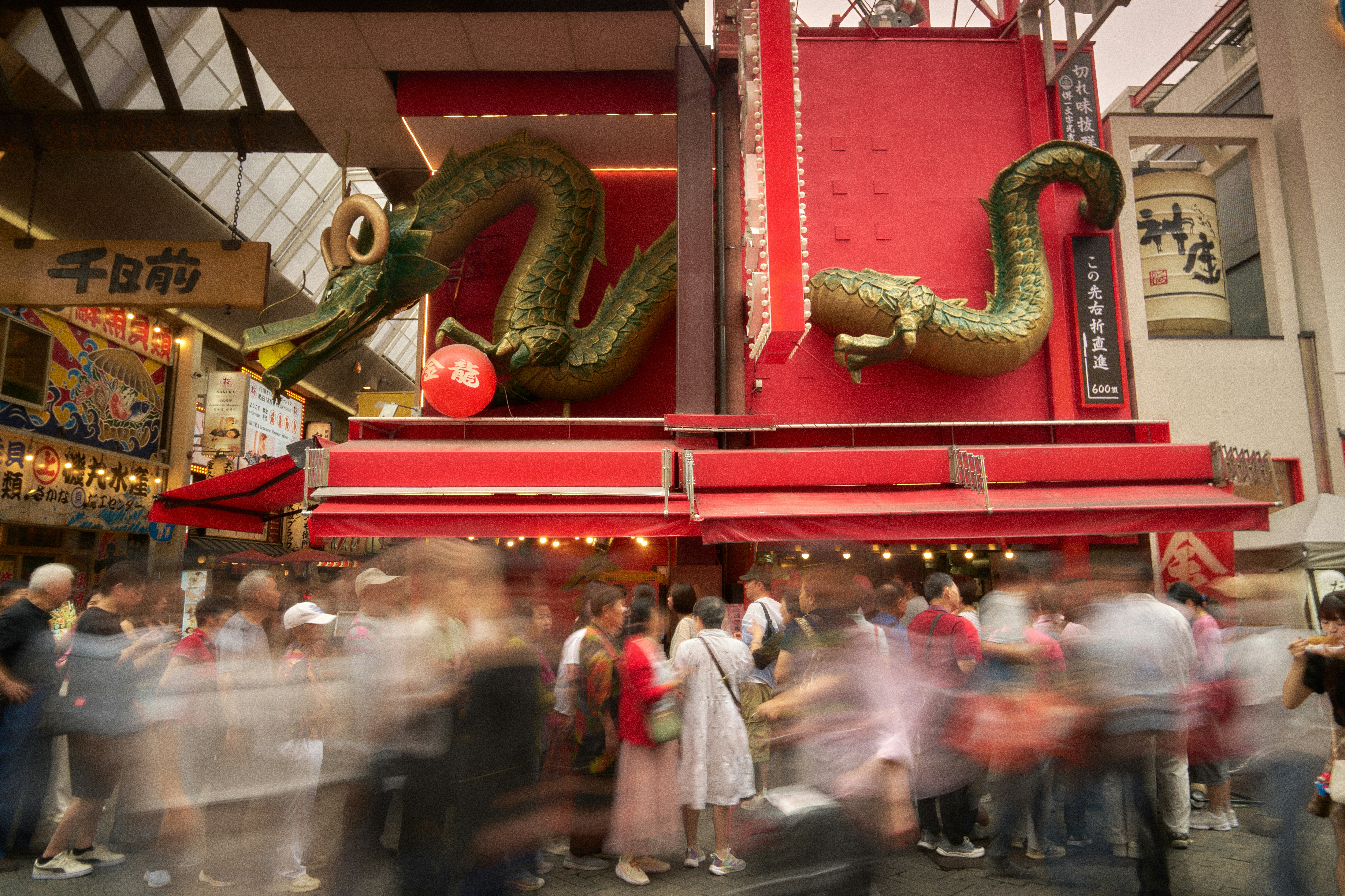 Crowds gather below a large green dragon decoration.