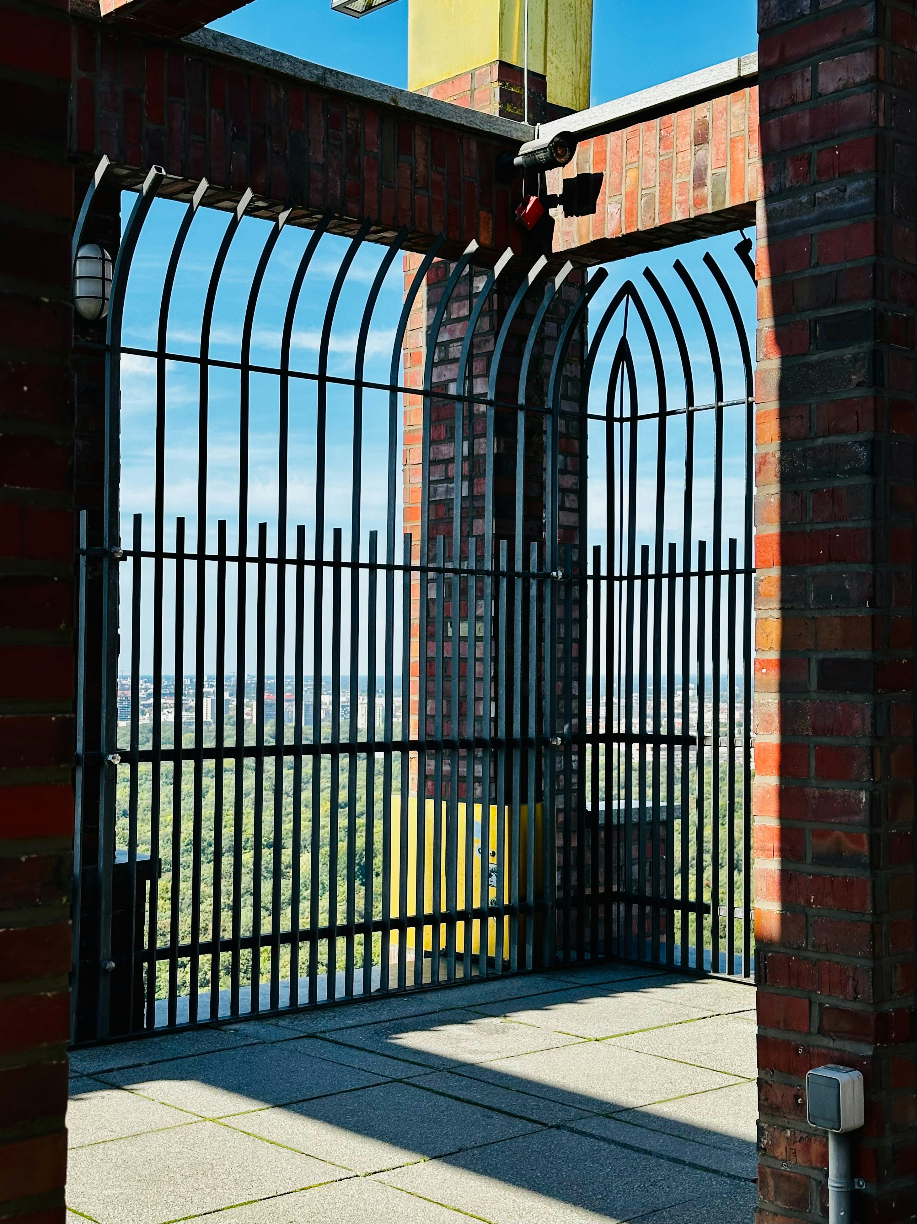 Metal gate with brick structure overlooking cityscape