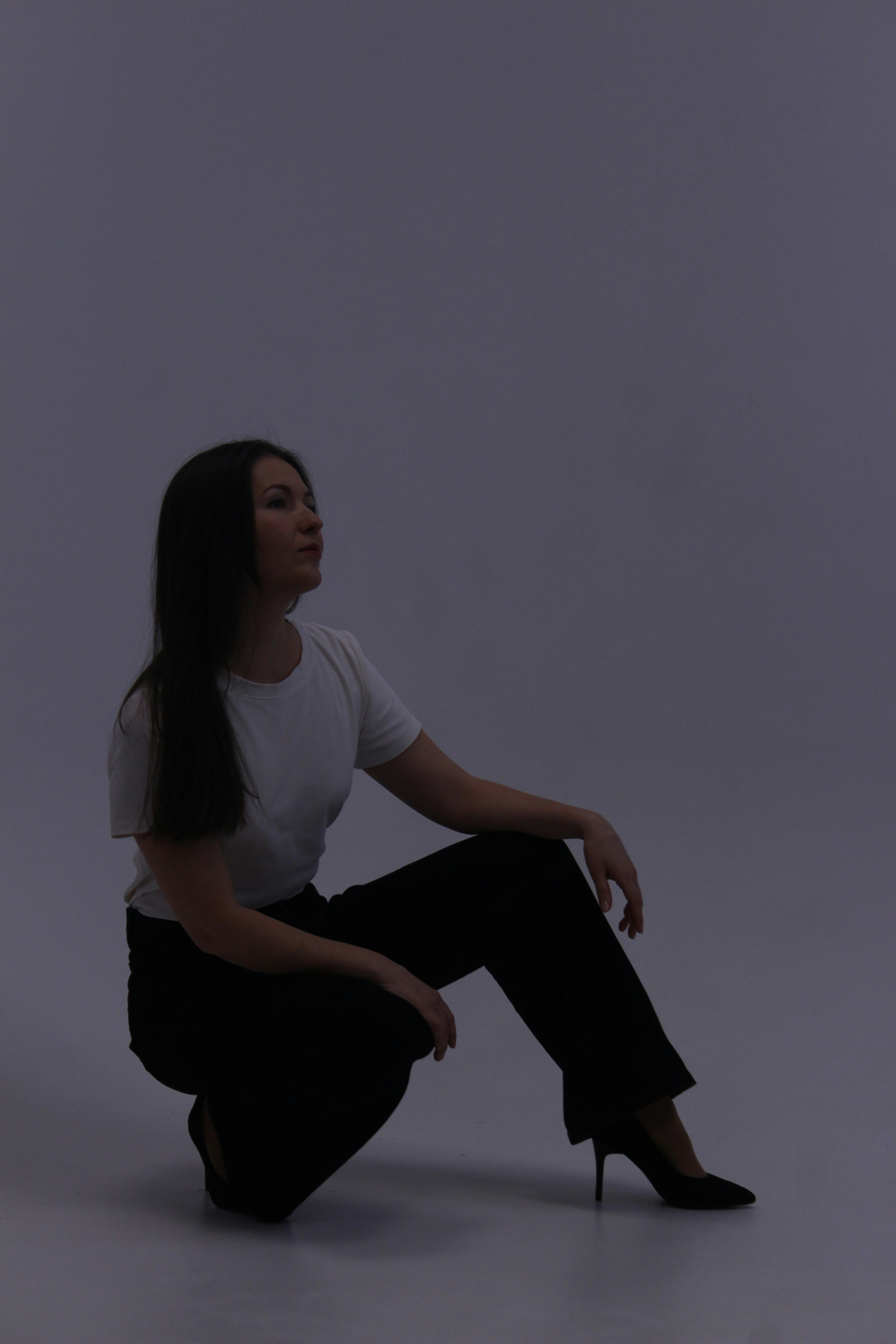 Woman in white shirt and black pants posing