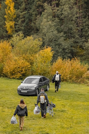 People walking towards car in autumn landscape