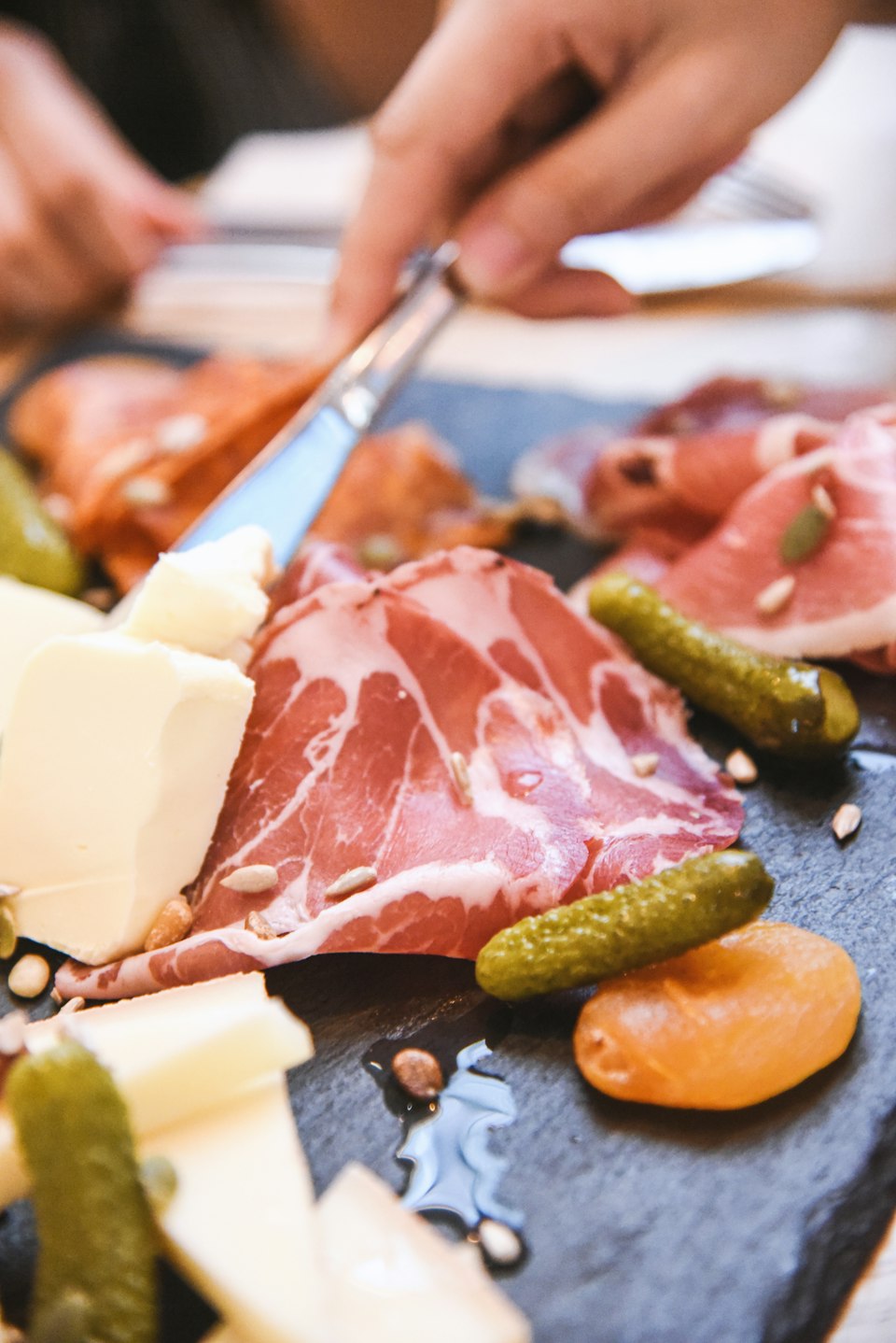 A rustic board of cured meats, cheese, and pickles for a home-cooked dinner