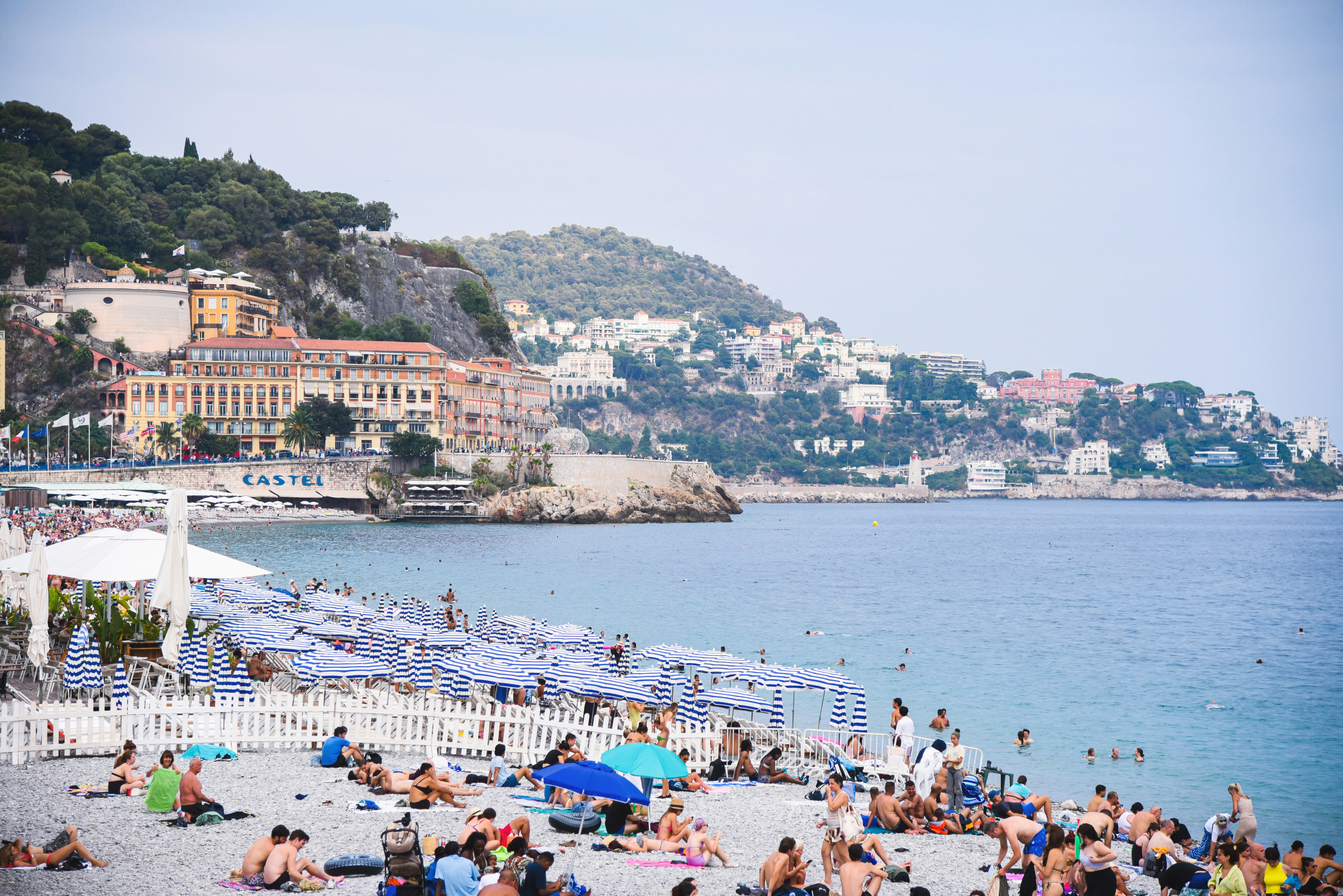 Crowded beach with buildings on a hill