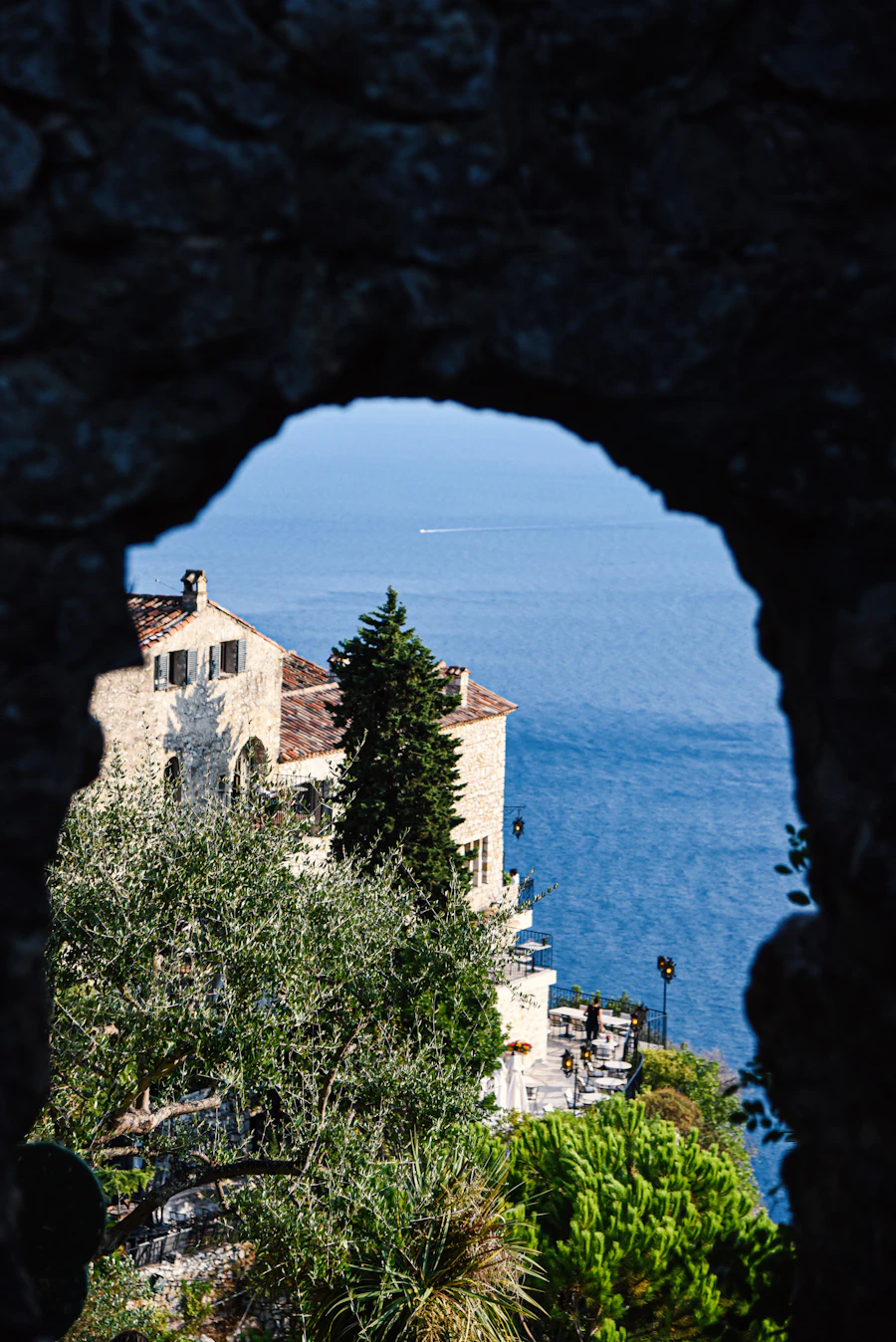 Maison de pierre aperçue depuis une arche à Èze