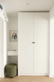 Modern entryway with white closet and green stool
