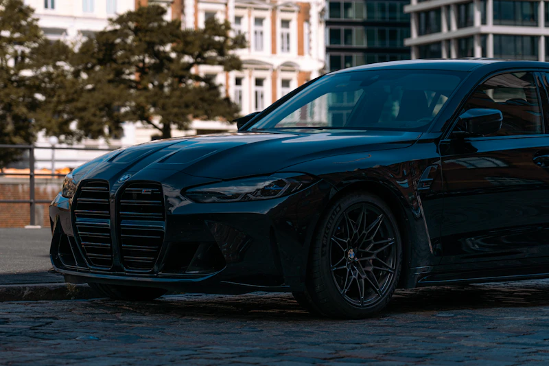 Sleek black car on a cobblestone street, understated elegance.